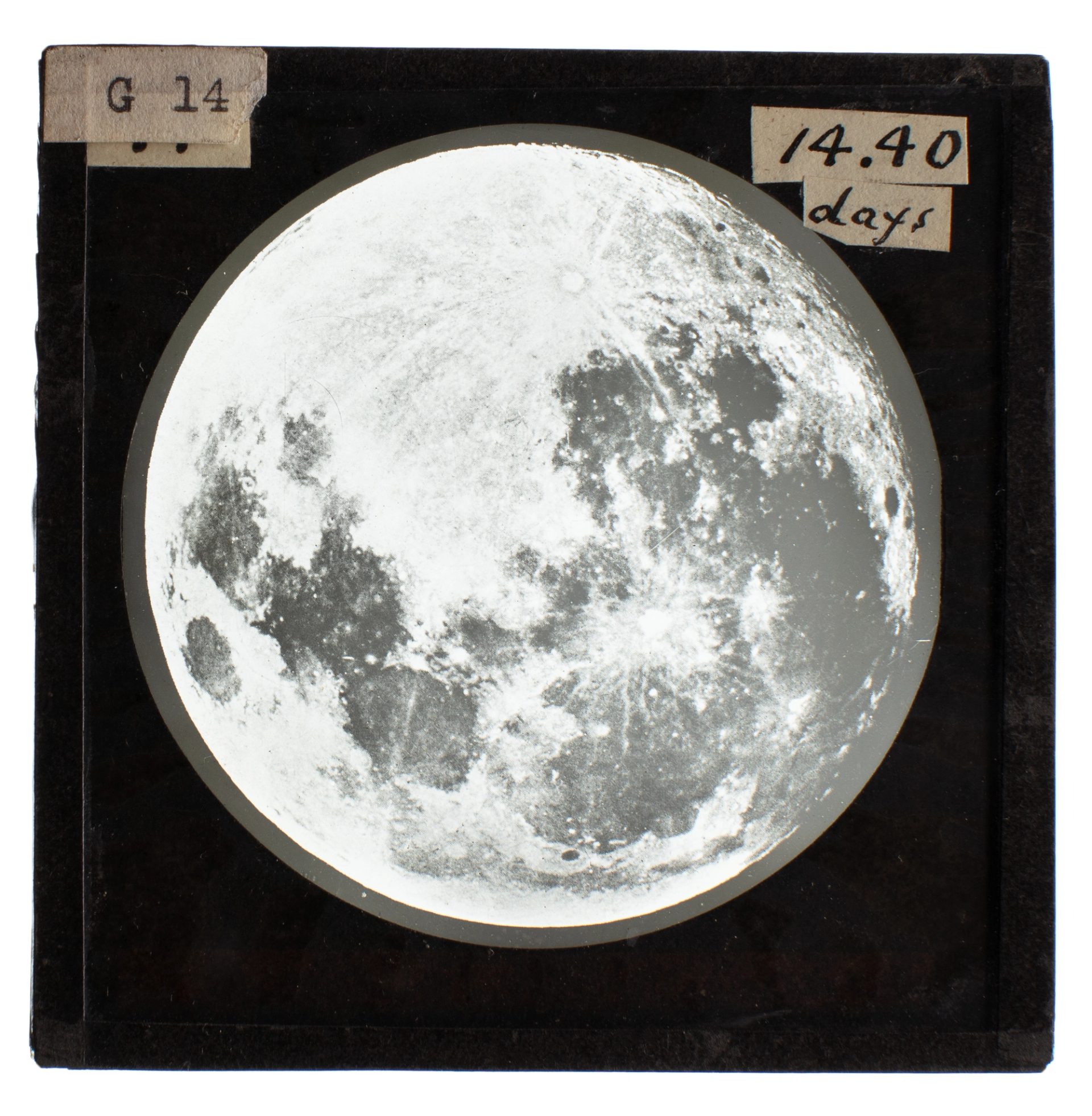 Black and white image of the moon in a black frame, a glass slide used for teaching astronomy.