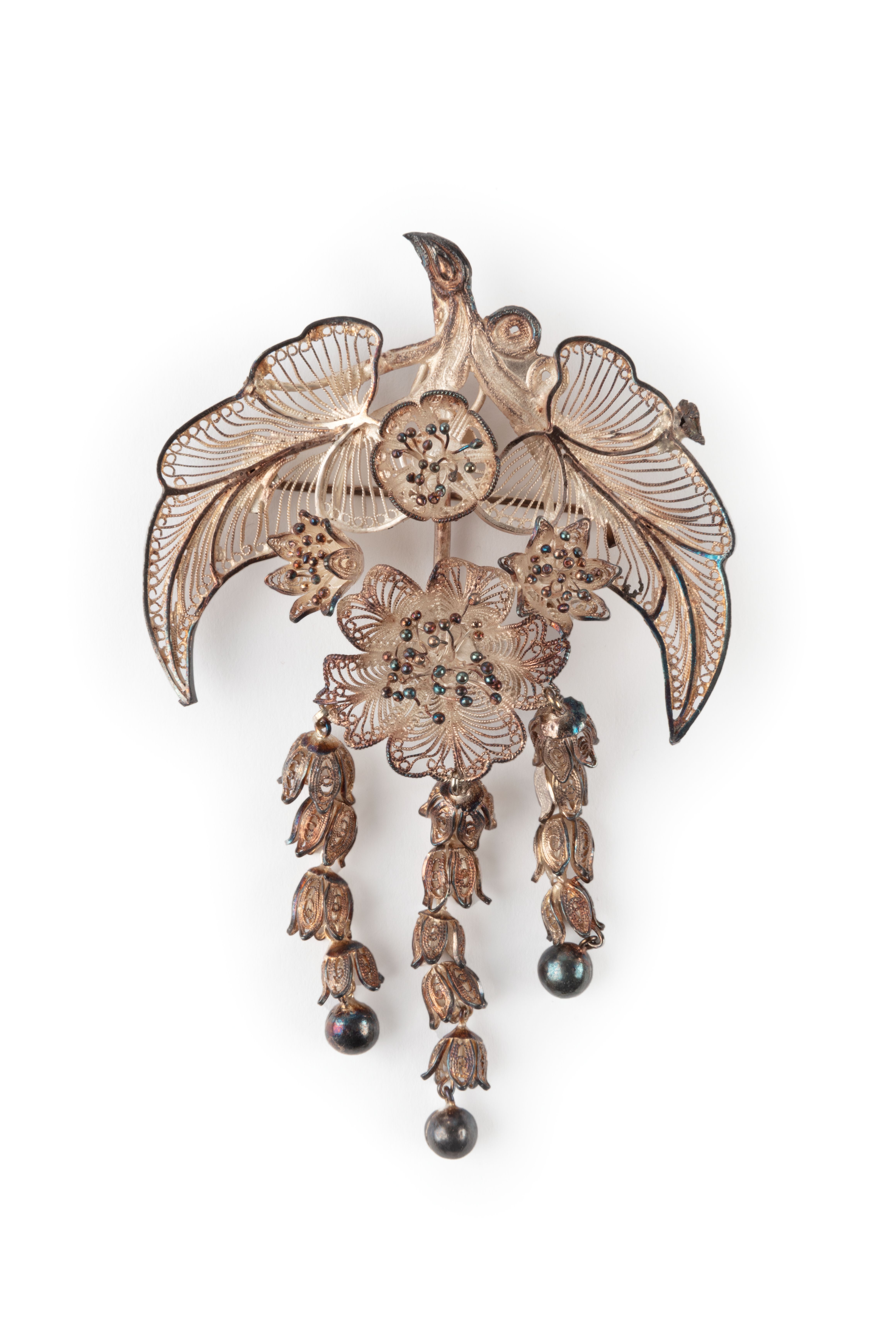 Five pieces of silver filigree jewellery comprising a pair of bangles, one floral spray brooch, and one pair of drop earrings, with cases.