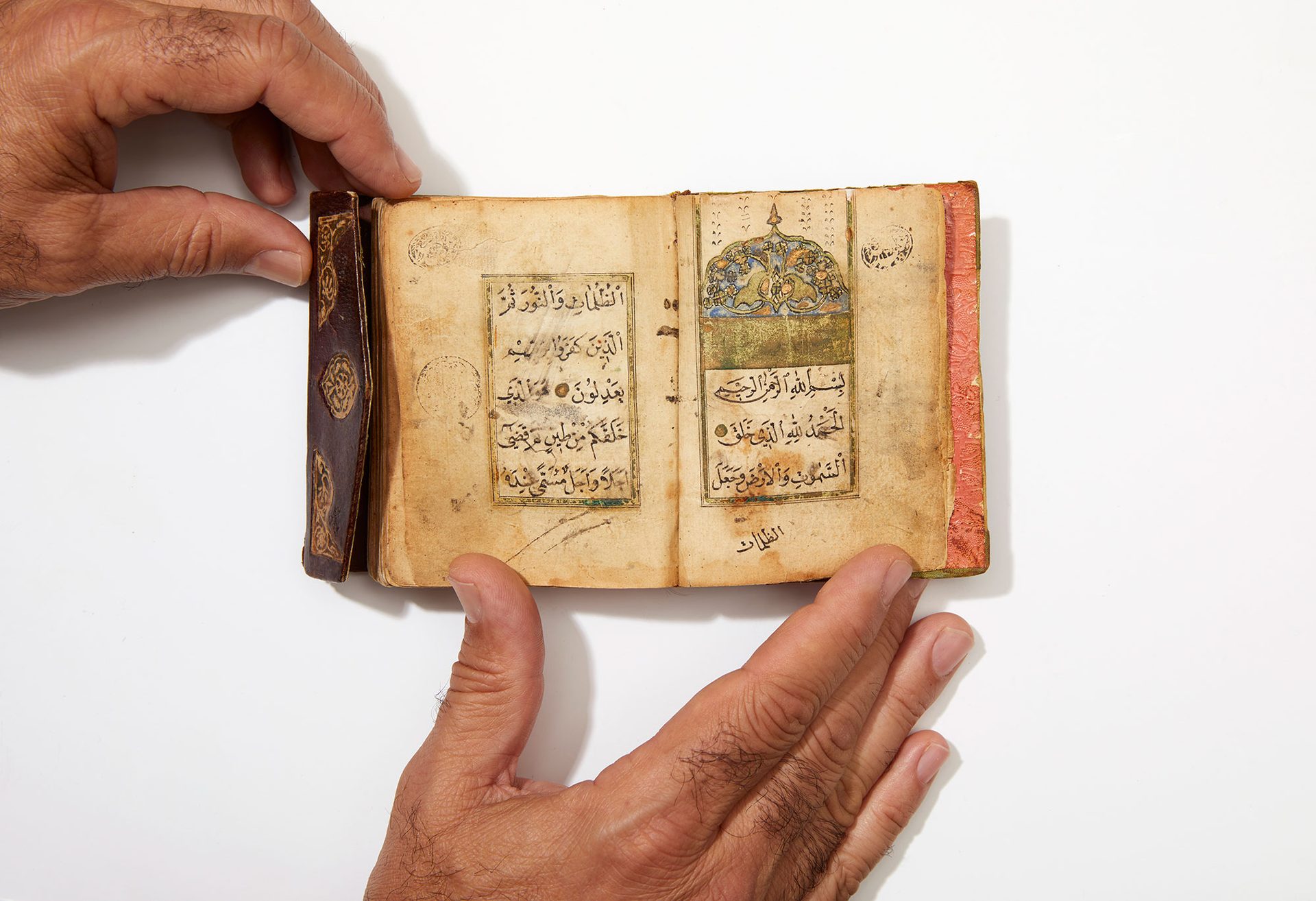 Photograph of Quran with two hands on page