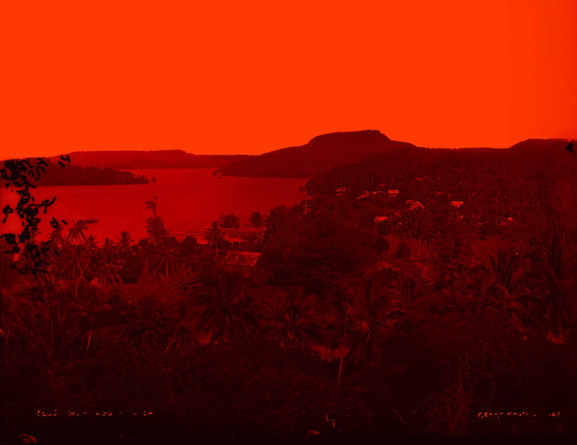 A harbourside town surrounded by heavily vegetated hills.