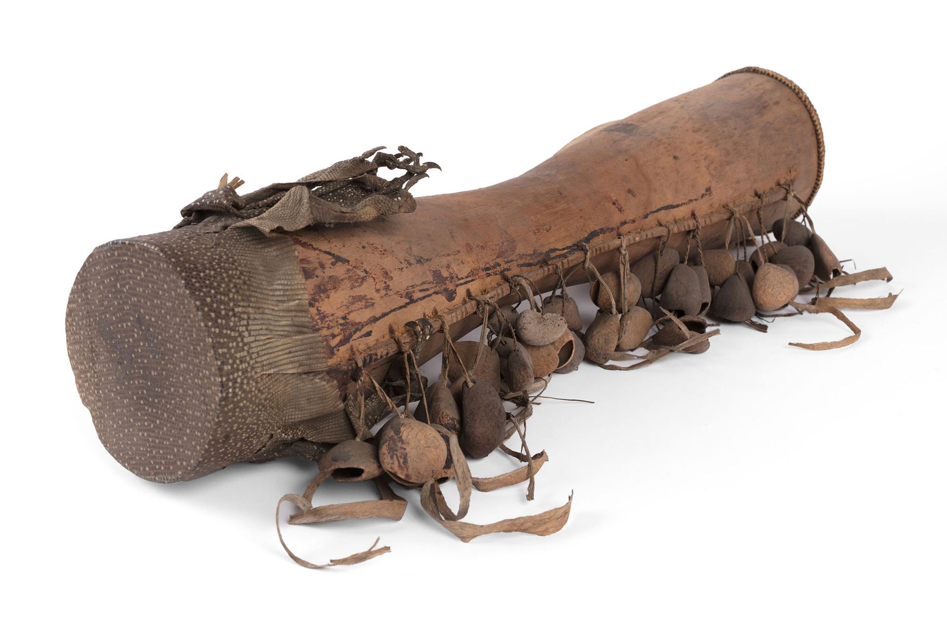 A small brown hand drum made with goanna skin and seed pods.