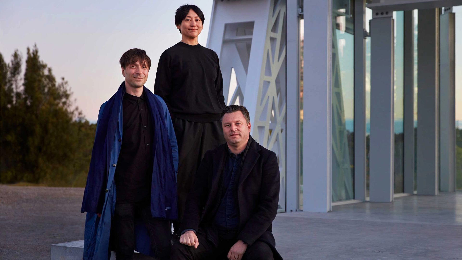 three people wearing black clothes looking towards the camera