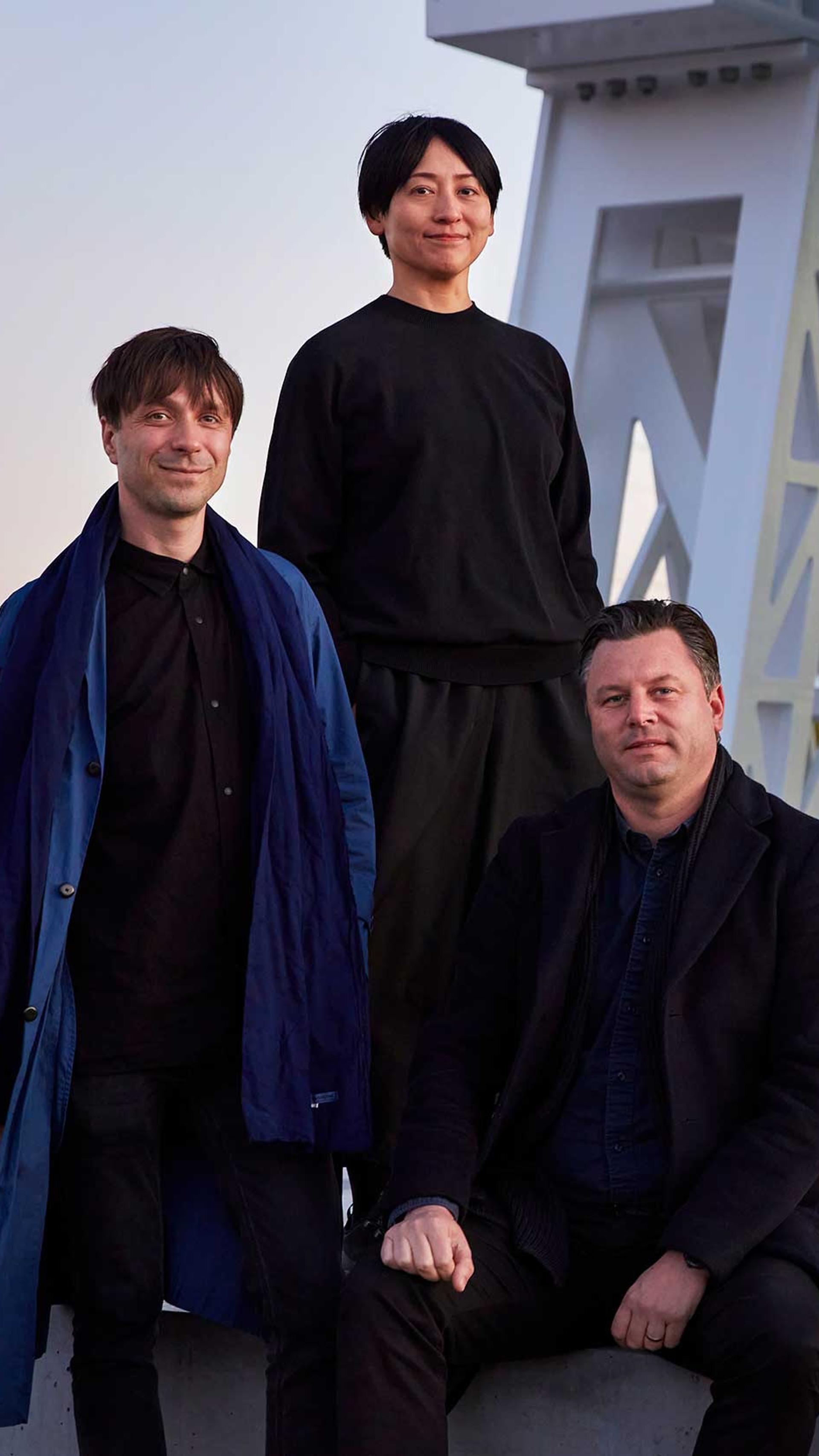 three people wearing black clothes looking towards the camera