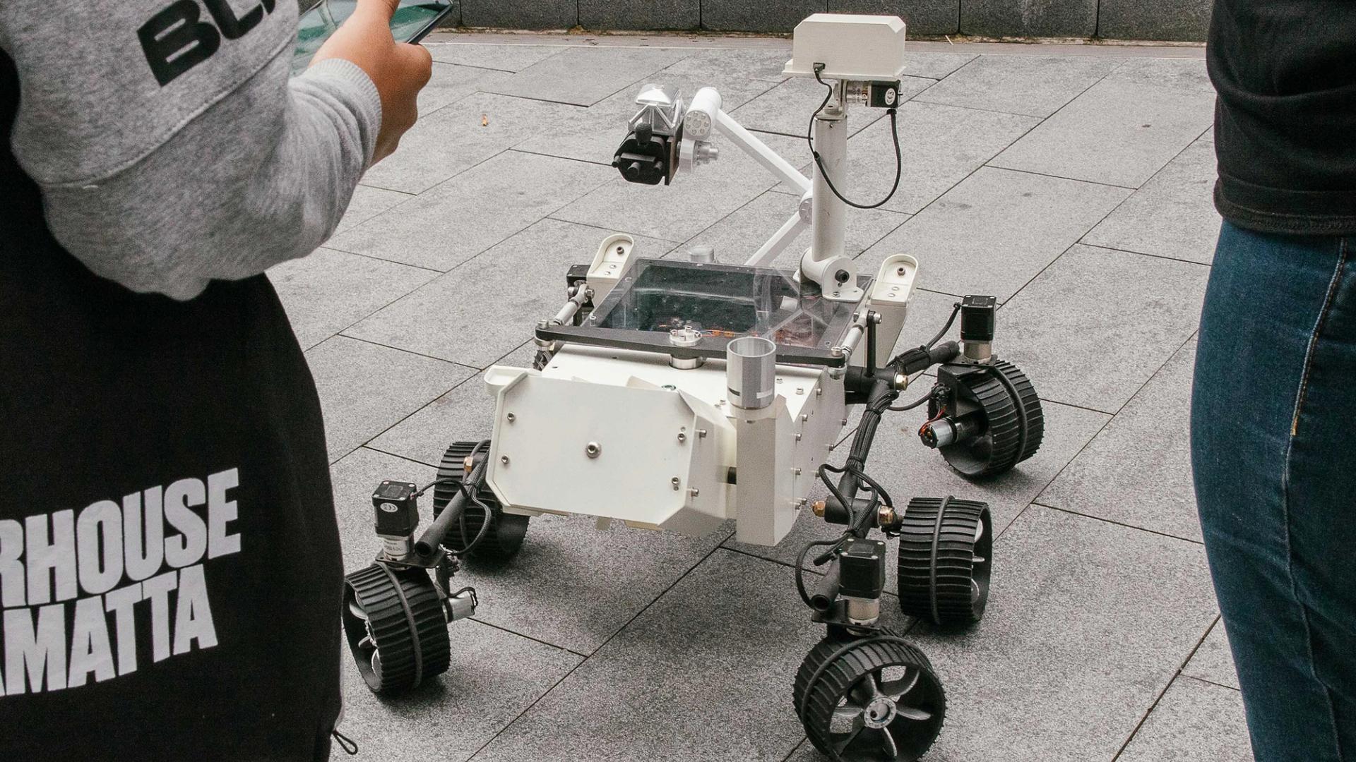 Mars Rover robot surrounded by kids.
