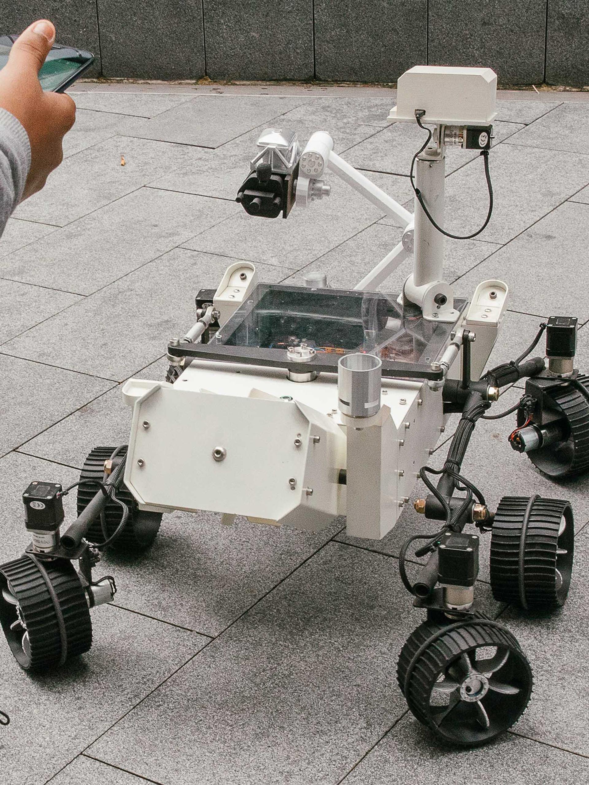 Mars Rover robot surrounded by kids.