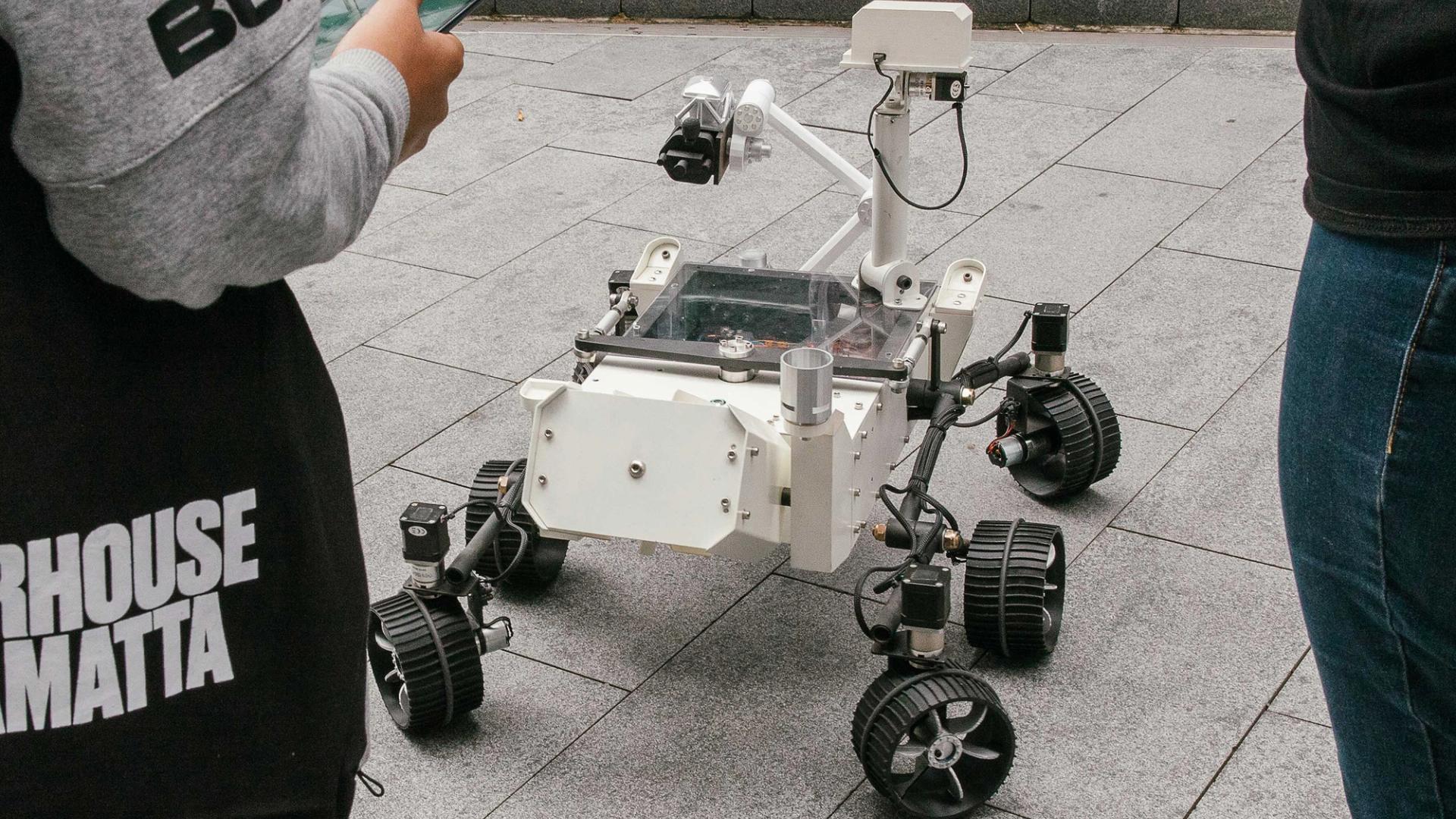 Mars Rover robot surrounded by kids.