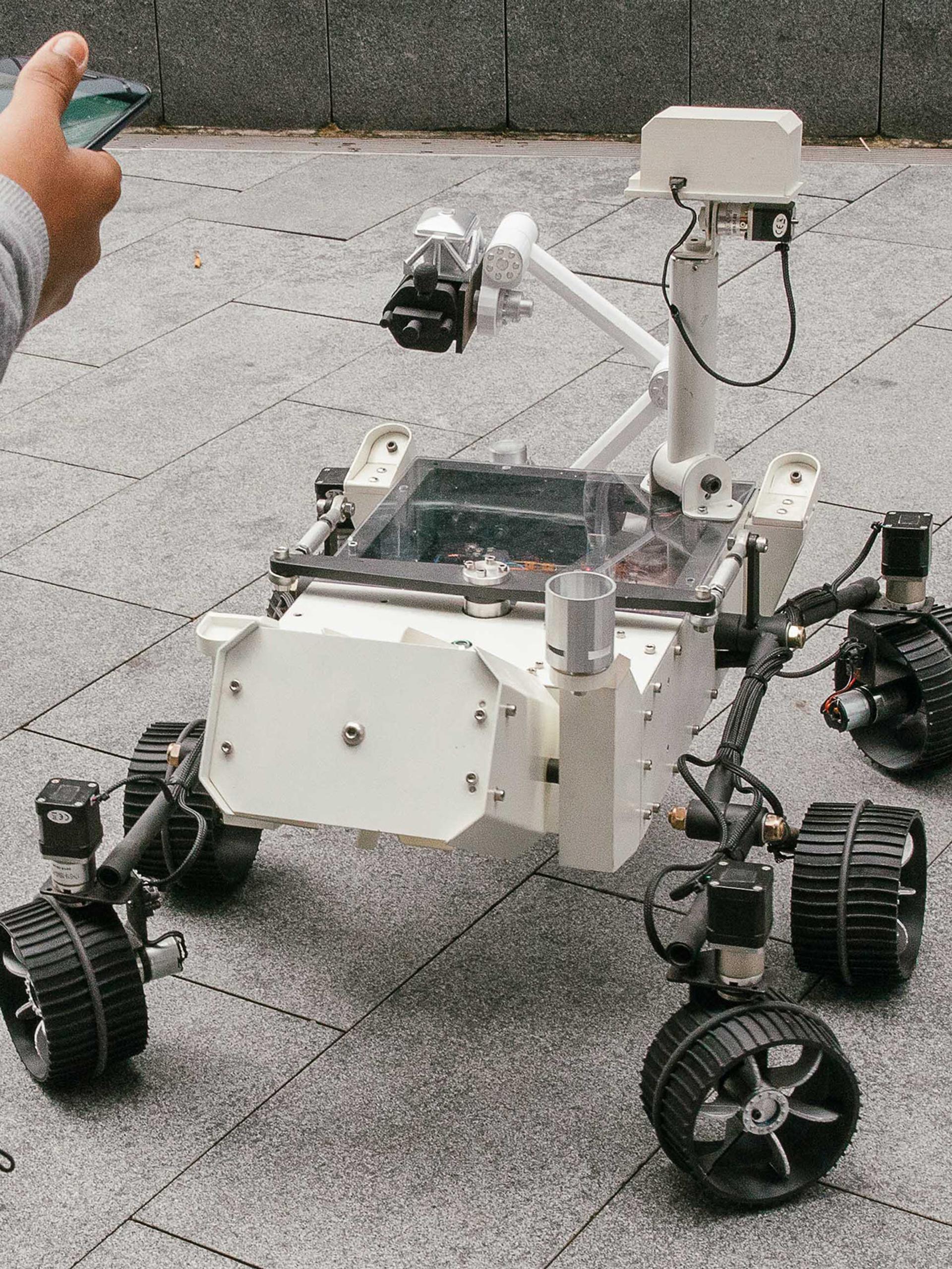 Mars Rover robot surrounded by kids.