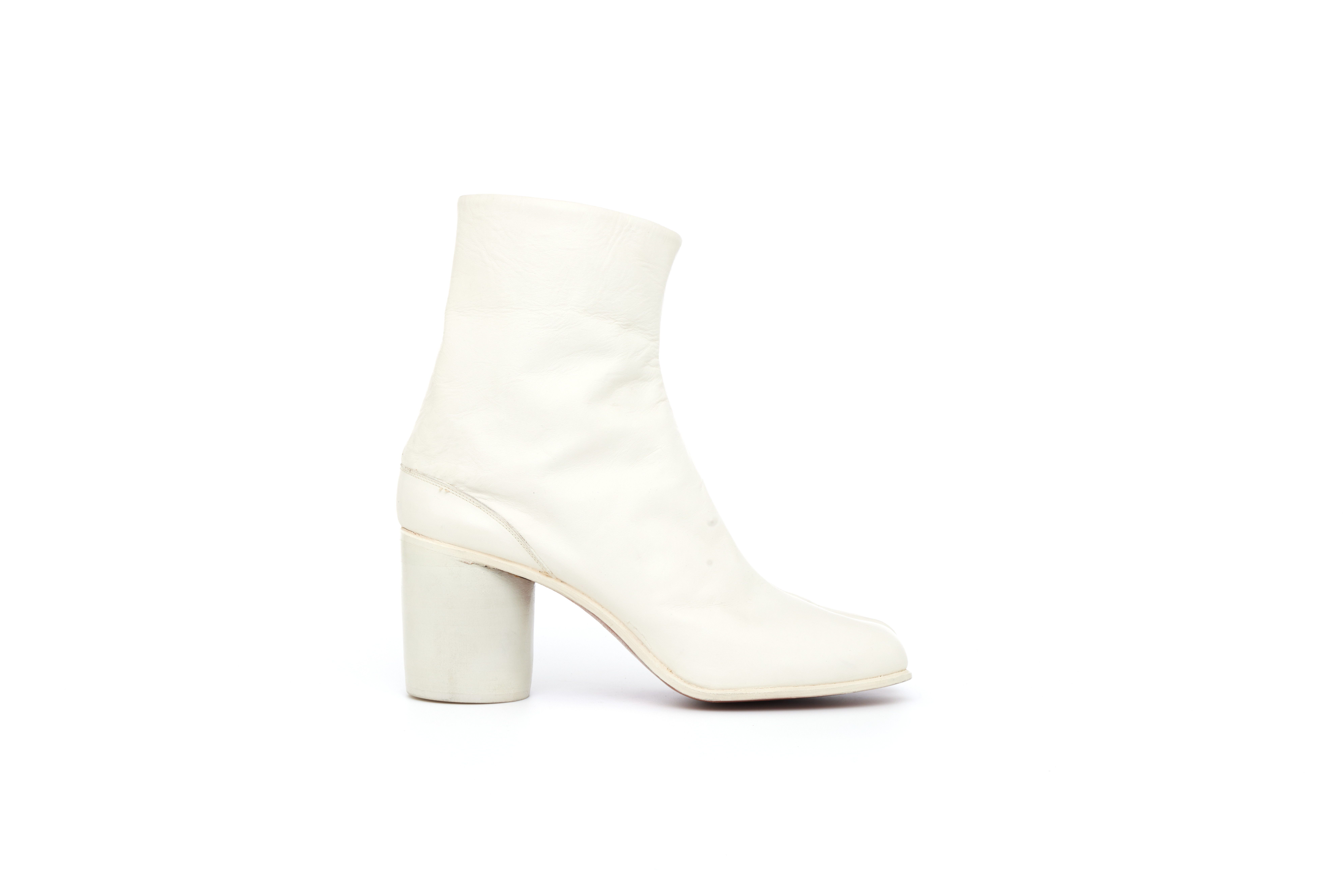 Pair of white, leather, women's ankle boots of cemented construction, with divided toe and round stacked and painted heel. The boot consists of white leather uppers in 2 pieces, seamed centre front and back which fasten at the back by metal hooks into 3 vertical piped rows on the lining.