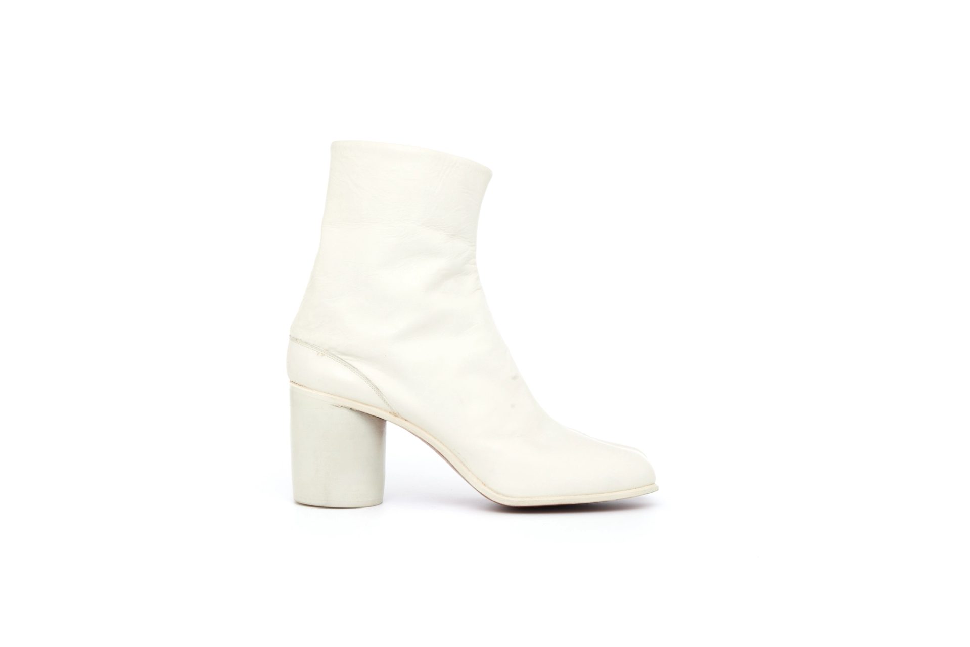 Pair of white, leather, women's ankle boots of cemented construction, with divided toe and round stacked and painted heel. The boot consists of white leather uppers in 2 pieces, seamed centre front and back which fasten at the back by metal hooks into 3 vertical piped rows on the lining.