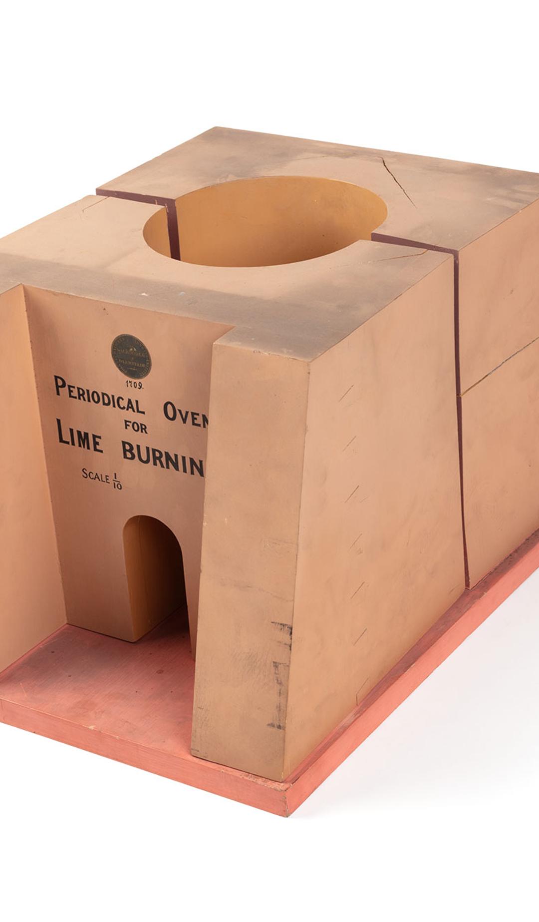 A model of a lime kiln or limestone burning furnace made from timber and metal. The front of the model reads ‘Periodical Oven For Lime Burning. Scale 1/10’.