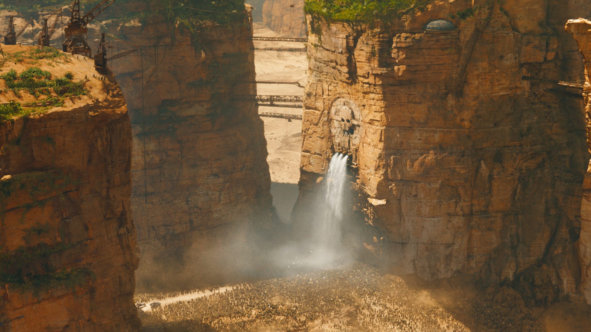 Waterfall falling below skull carved into cliffside.