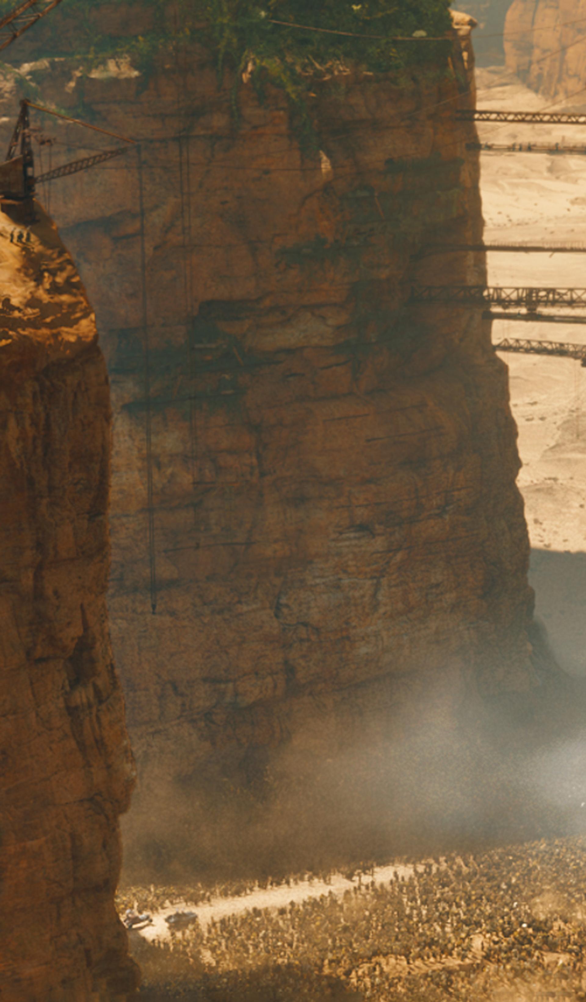 Waterfall falling below skull carved into cliffside.