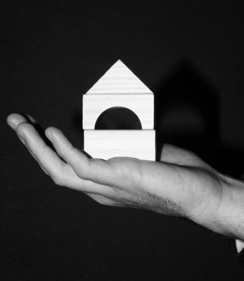 Hand holding up building blocks made from wood