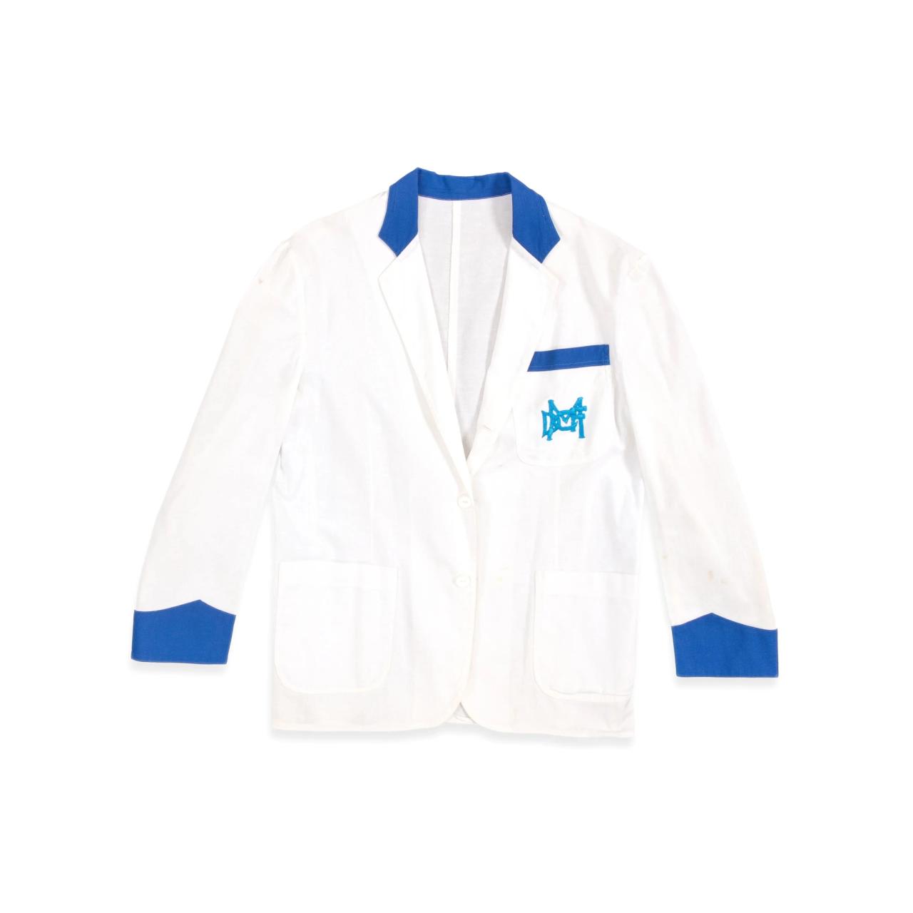White cotton milk cart driver's jacket with royal blue collar, pocket and cuff trim and royal blue ‘Dairy Farmers’ insignia on left breast pocket.