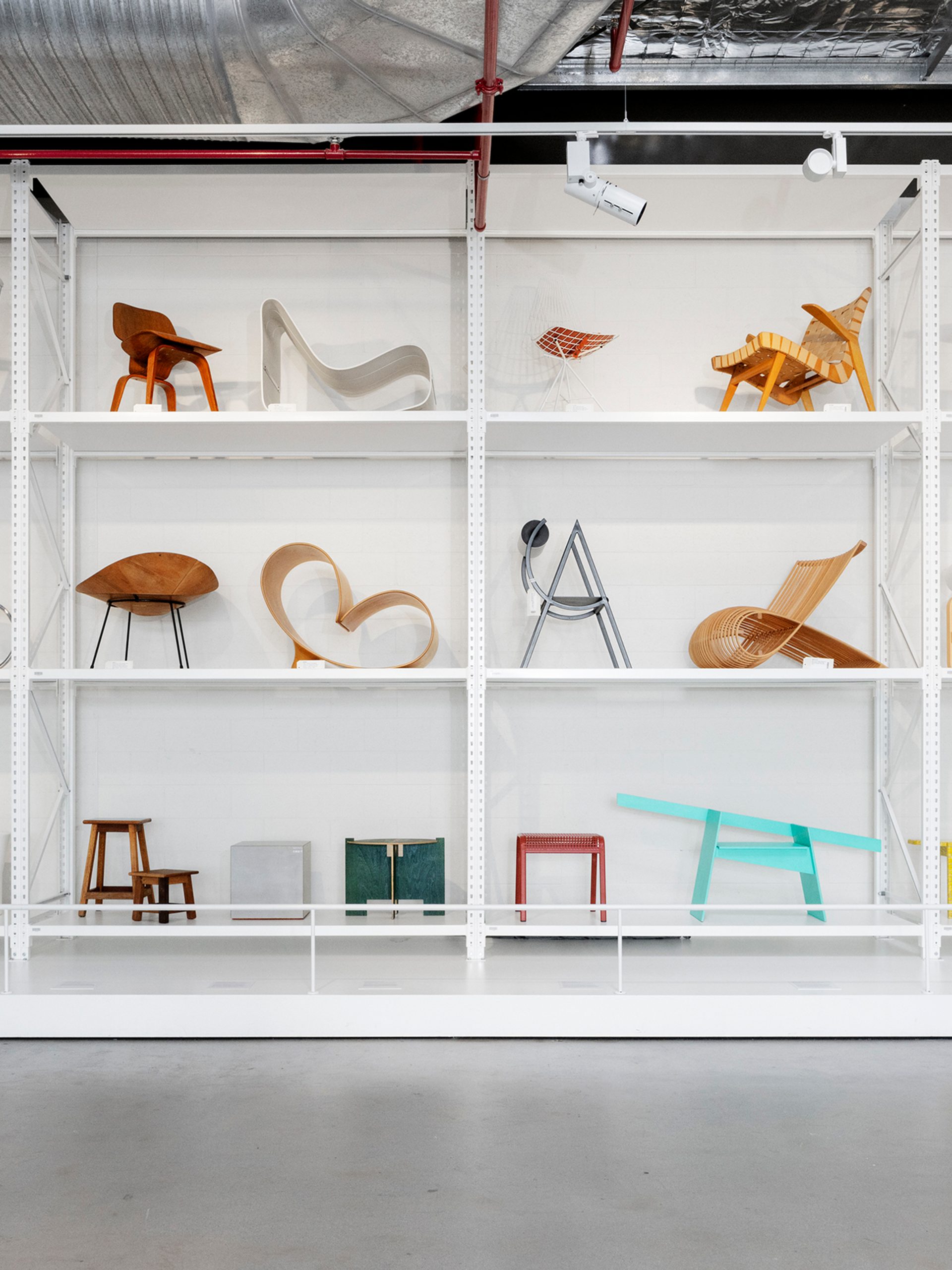 Three shelves filled with colourful chairs and stools.