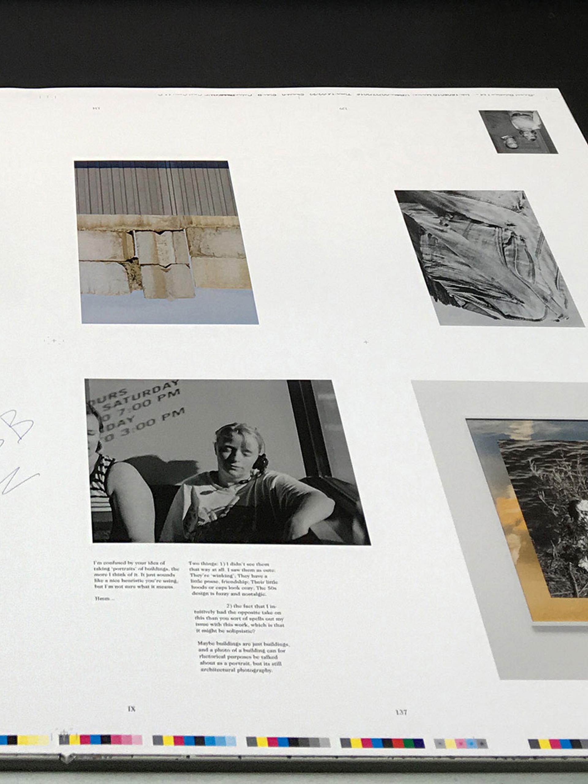 Printed pages lie on the printing press, a mixture of black and white, colour images and text.
