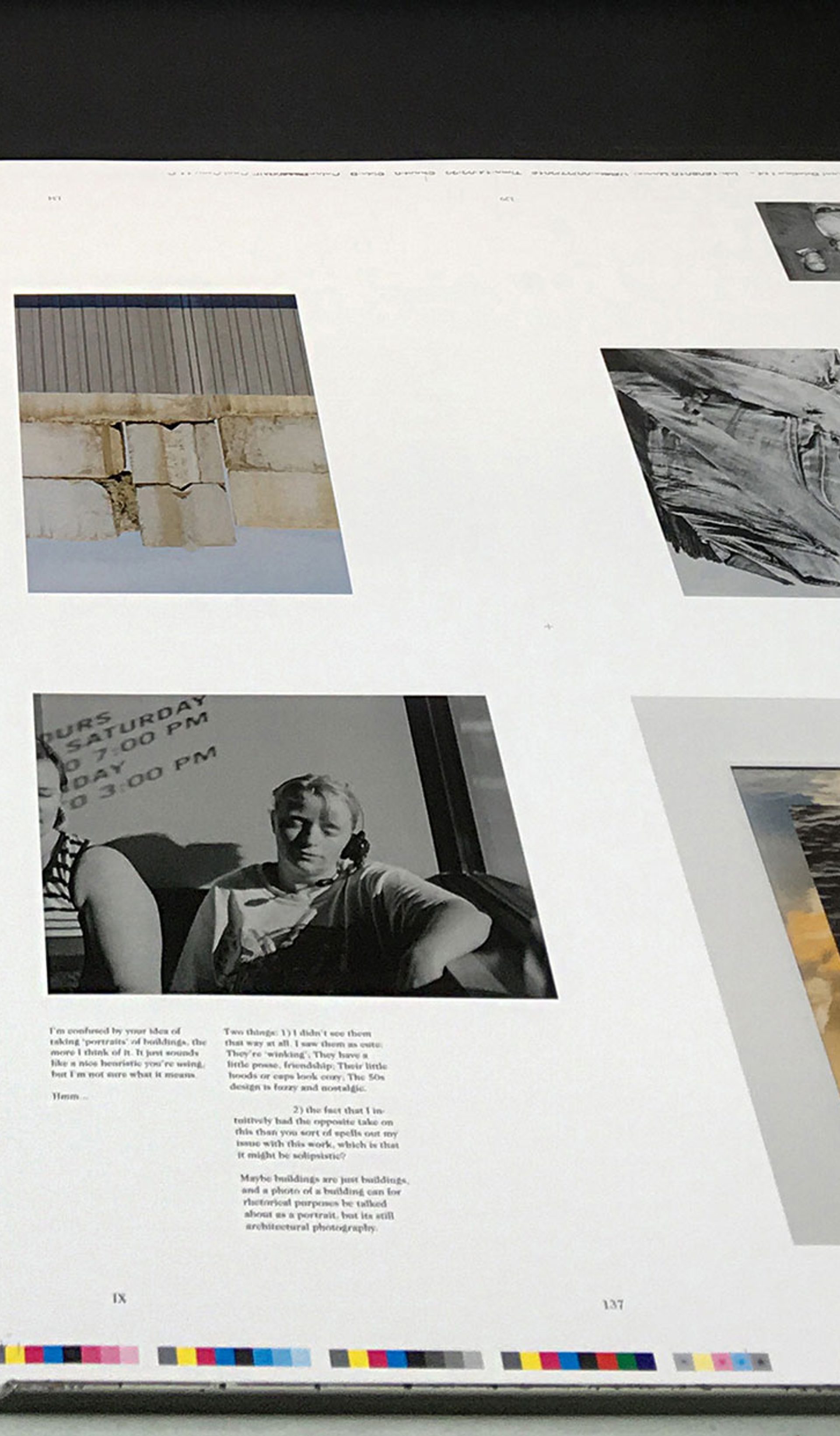 Printed pages lie on the printing press, a mixture of black and white, colour images and text.