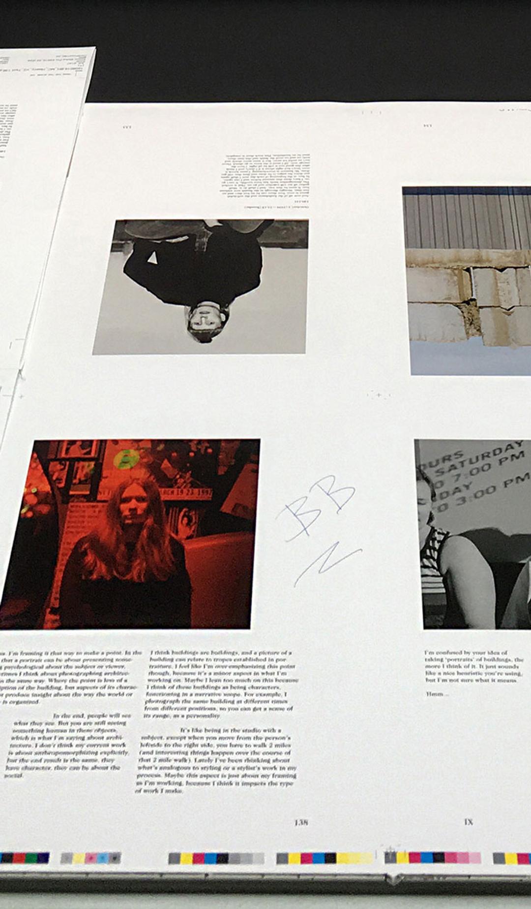 Printed pages lie on the printing press, a mixture of black and white, colour images and text.