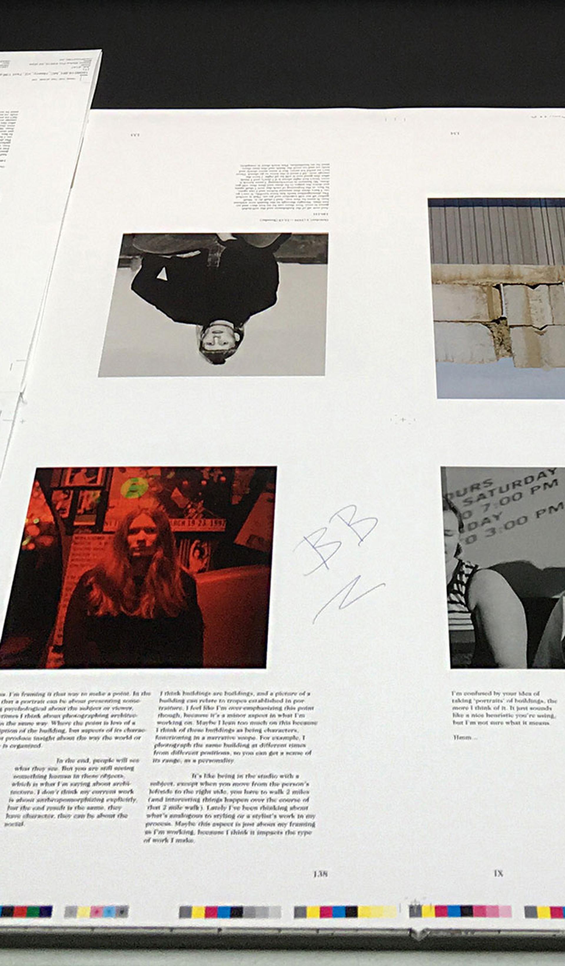 Printed pages lie on the printing press, a mixture of black and white, colour images and text.