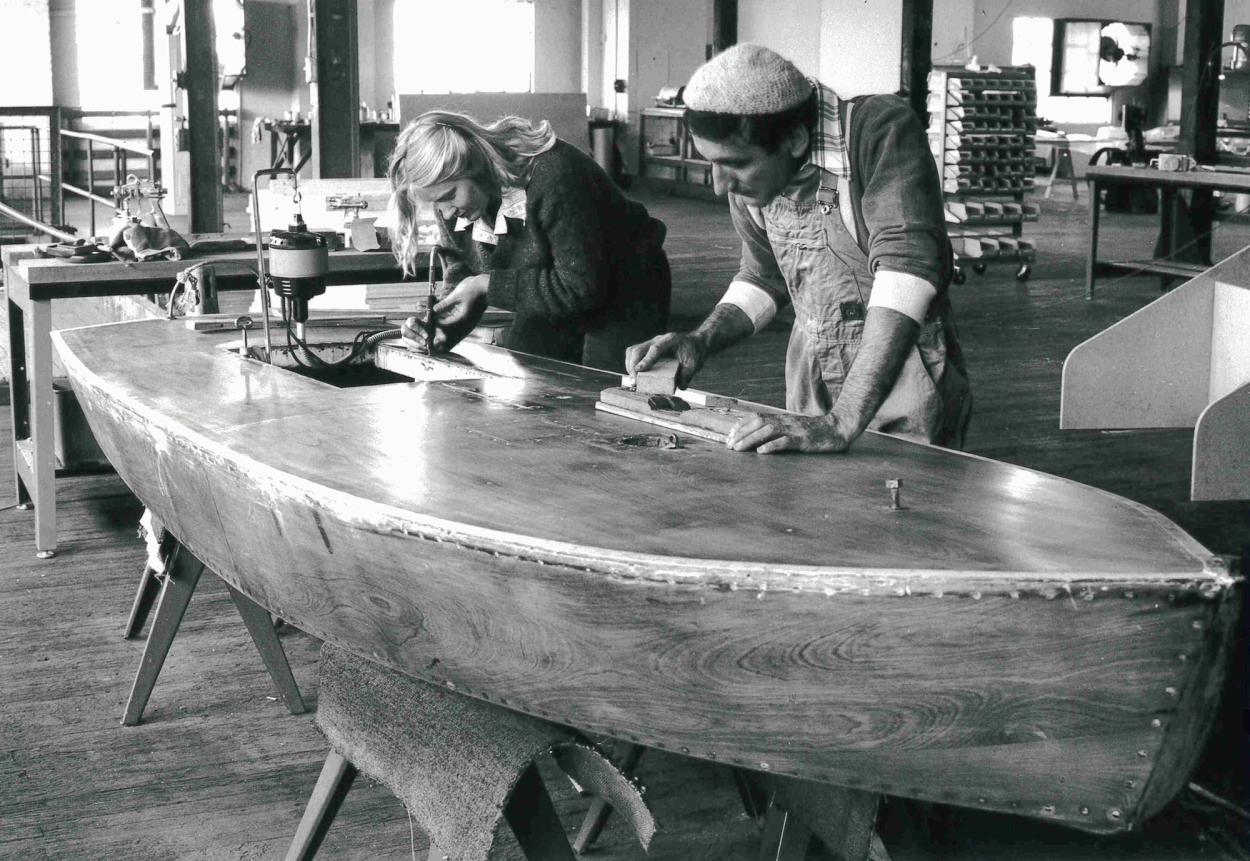 Black and white image of two preparators restoring a boat