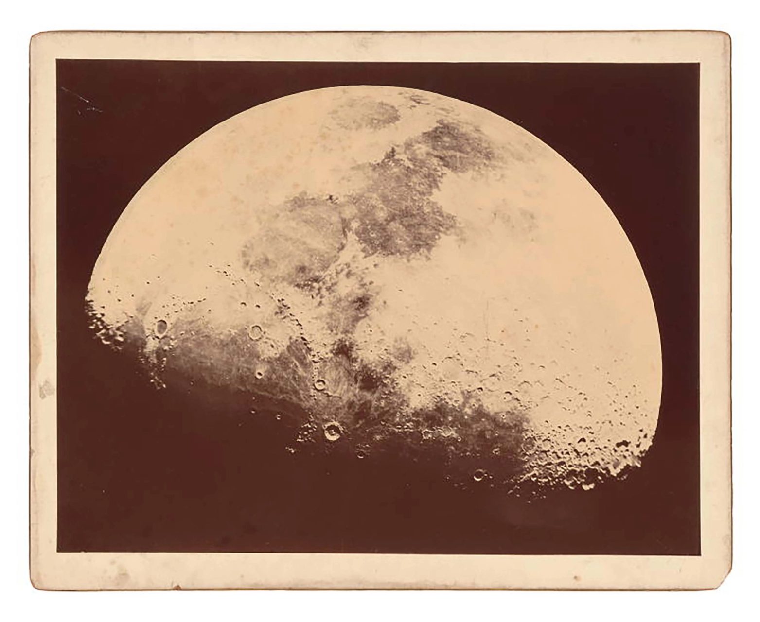 Aged photographic print, in sepia tones, of a gibbous (slightly past half-lit) Moon.