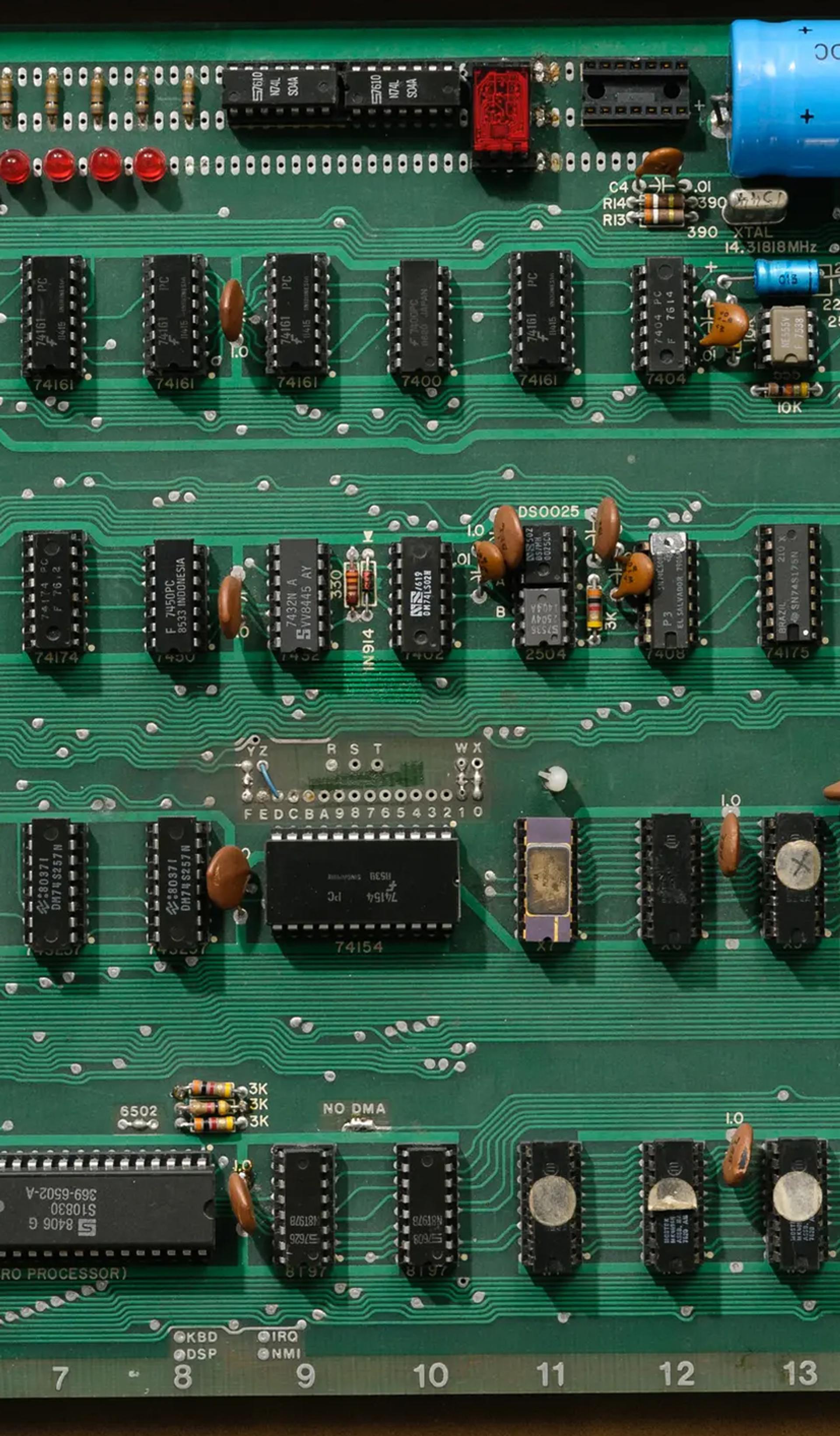 An open briefcase revealing the Apple 1 printed circuit board and components attached to the underside of the briefcase lid.