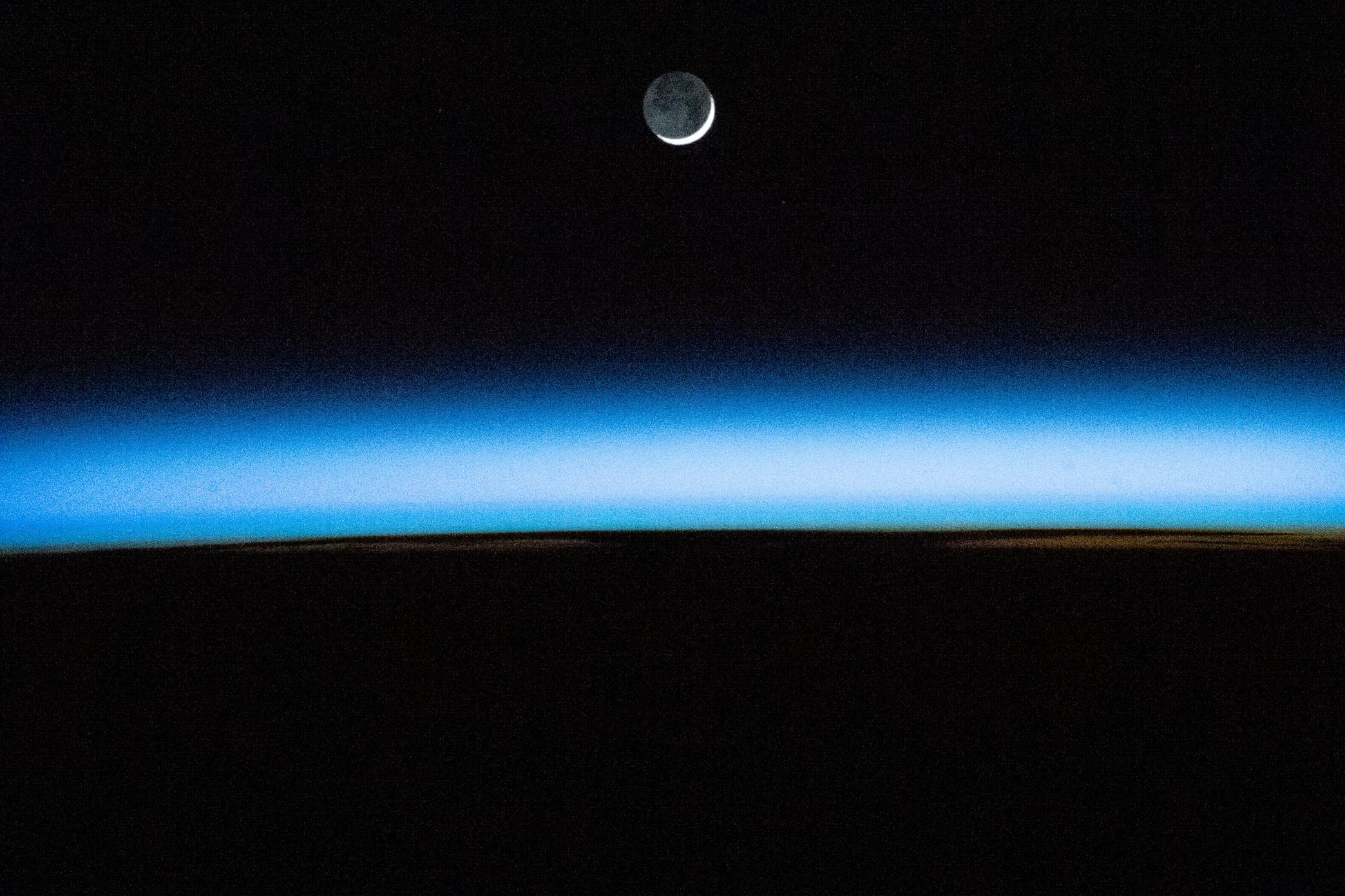 The waxing crescent Moon above Earth's atmosphere
