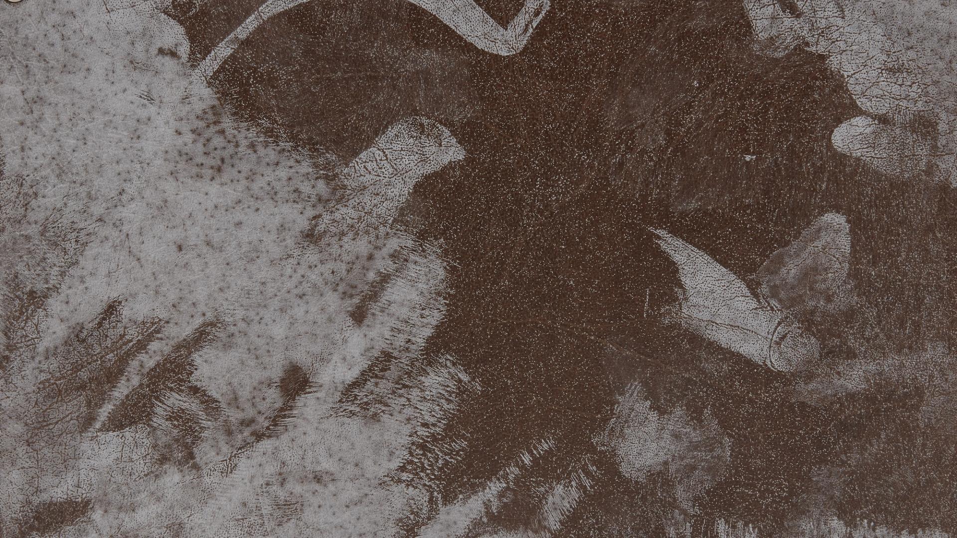Section of a leather case with white paint stains.