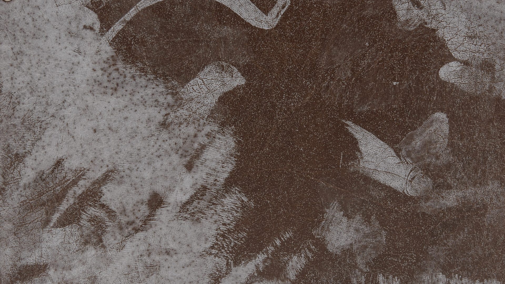 Section of a leather case with white paint stains.