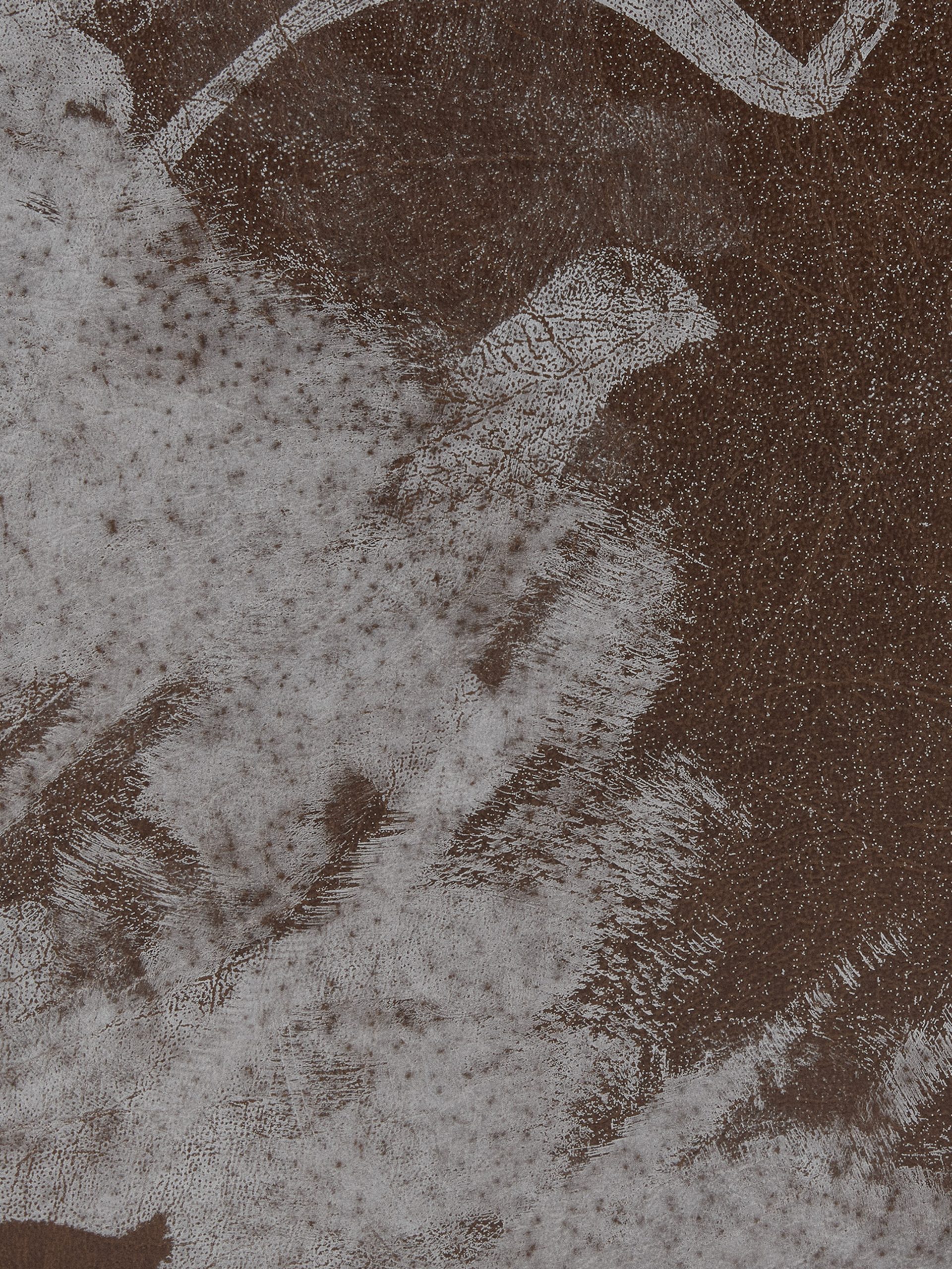 Section of a leather case with white paint stains.