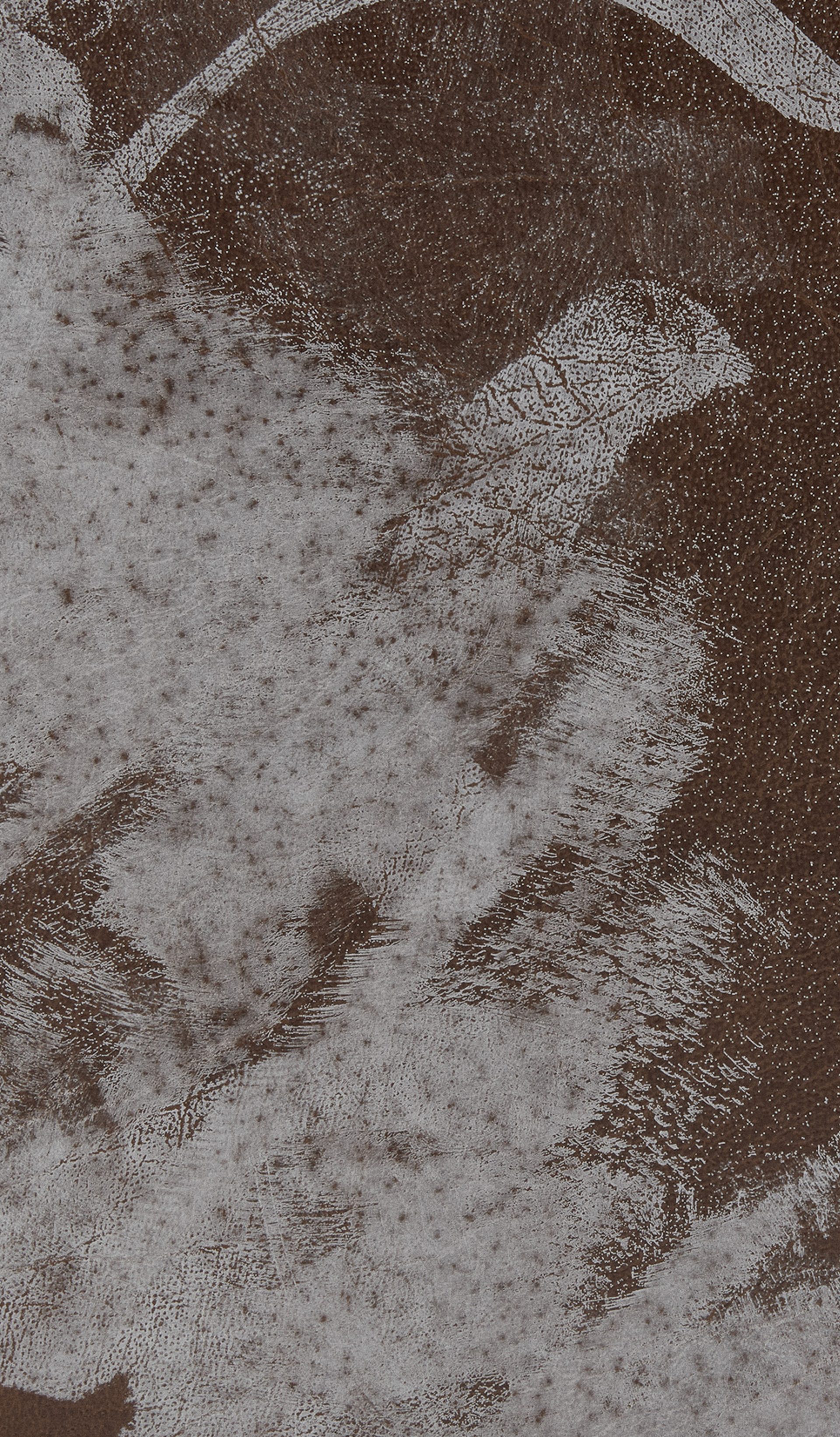 Section of a leather case with white paint stains.