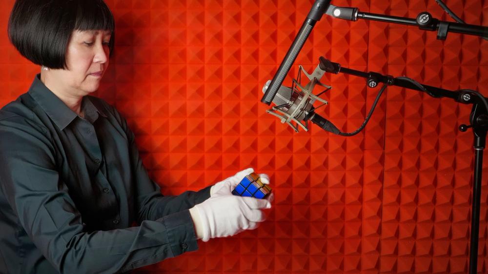 Woman with rubix cube in red recording studio