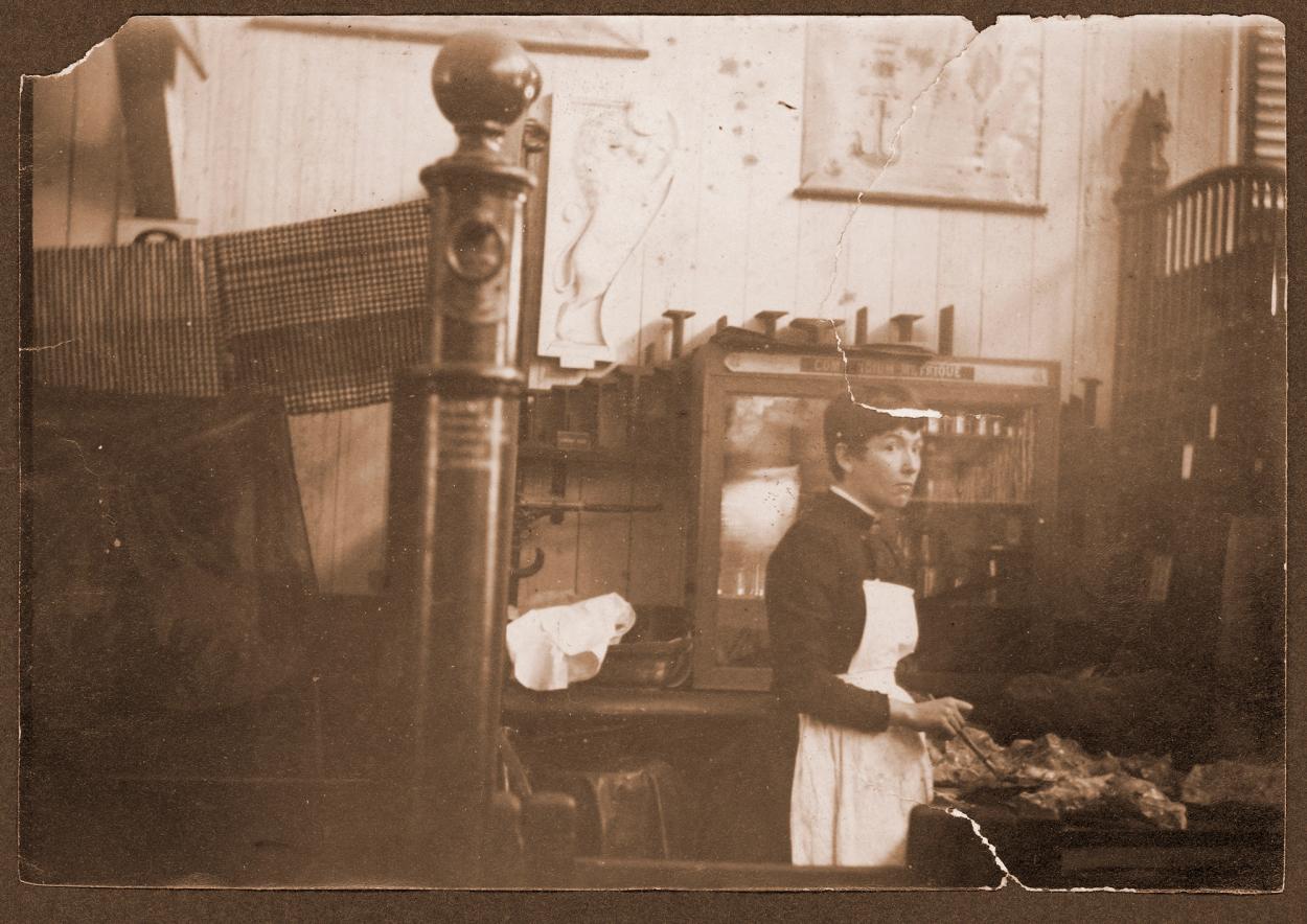 Sepia photograph of a woman retouching gold nugget specimens