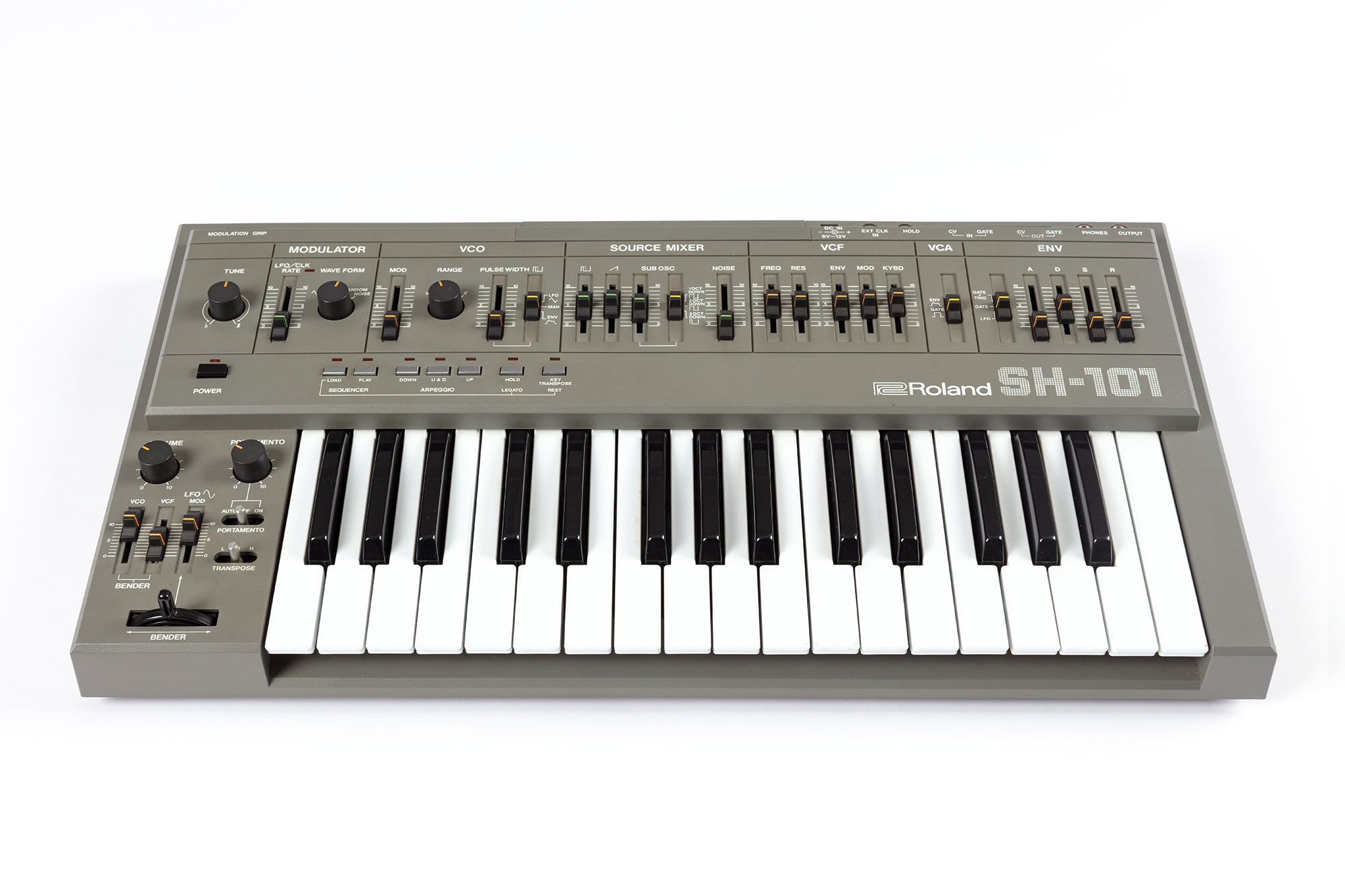 A grey synthesiser with multiple dials and sliders. It has a keyboard that spans two and a half octaves from f to c.