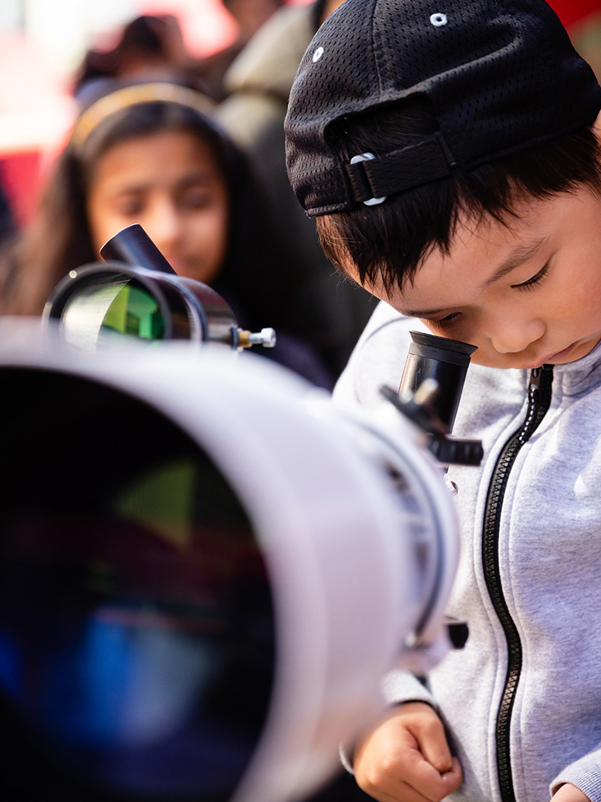 Little boy looks through telescope.