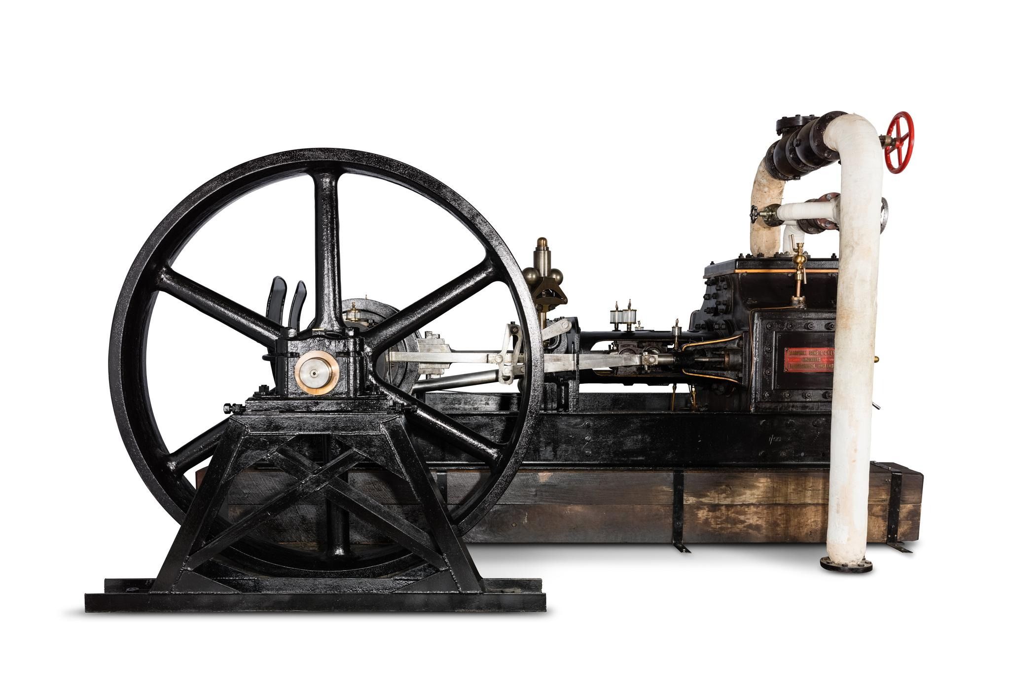 Side view of a steam engine with a large wheel driven by a piston