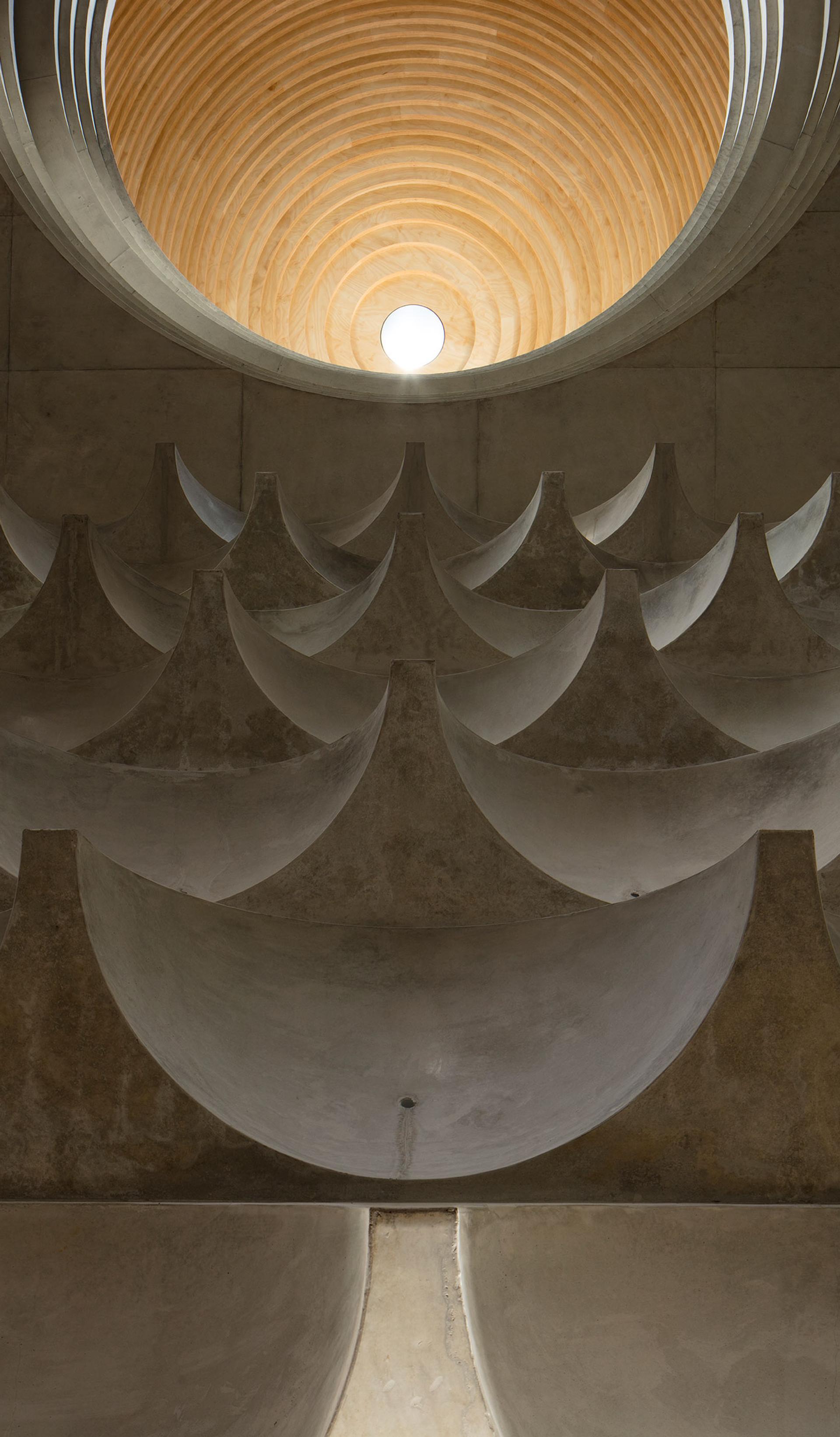 Interior view of mosque ceiling formed from multiple concrete cast half domes and one central timber clad dome