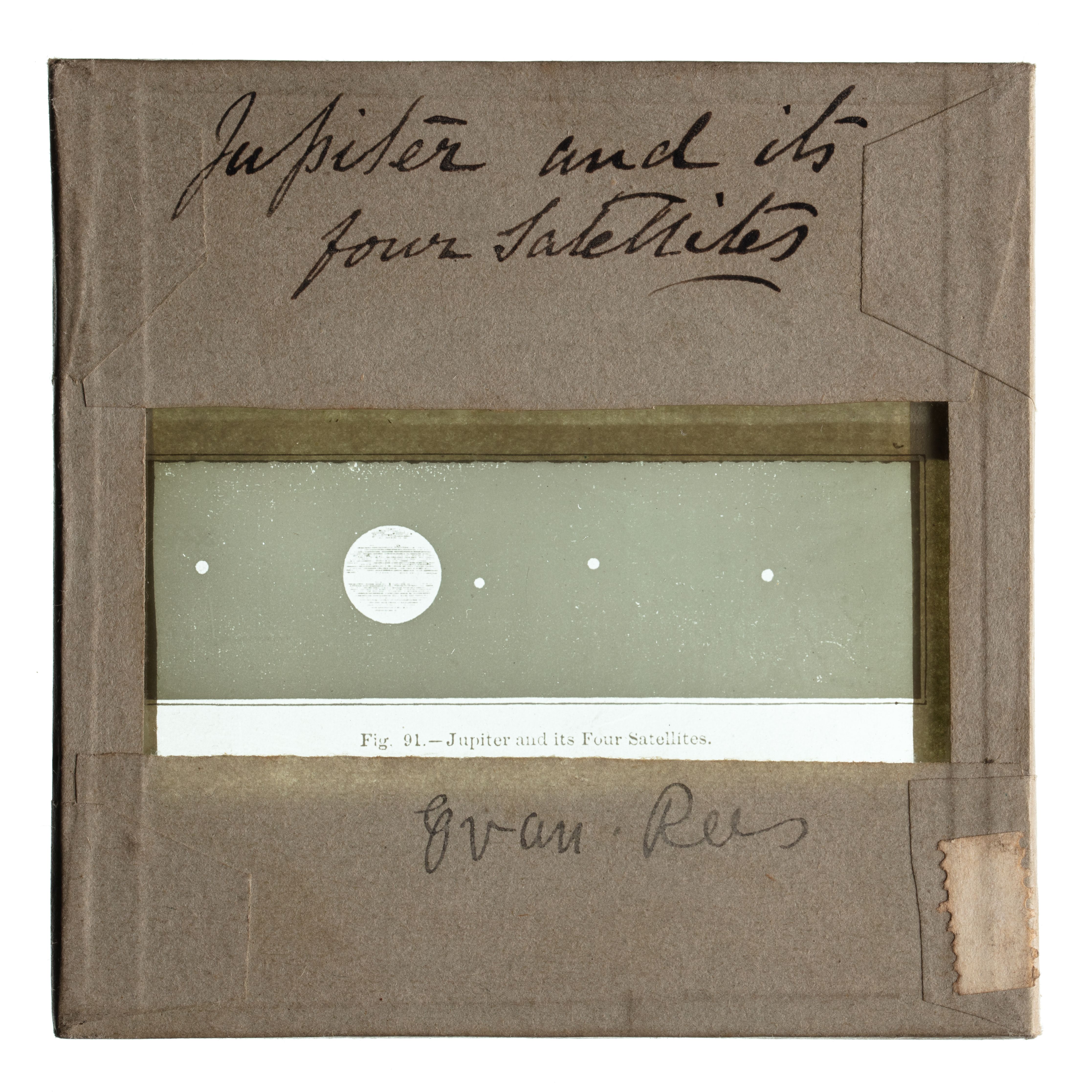 A glass plate slide with borders wrapped in tape, a rectangular window shows Jupiter & its four satellites.