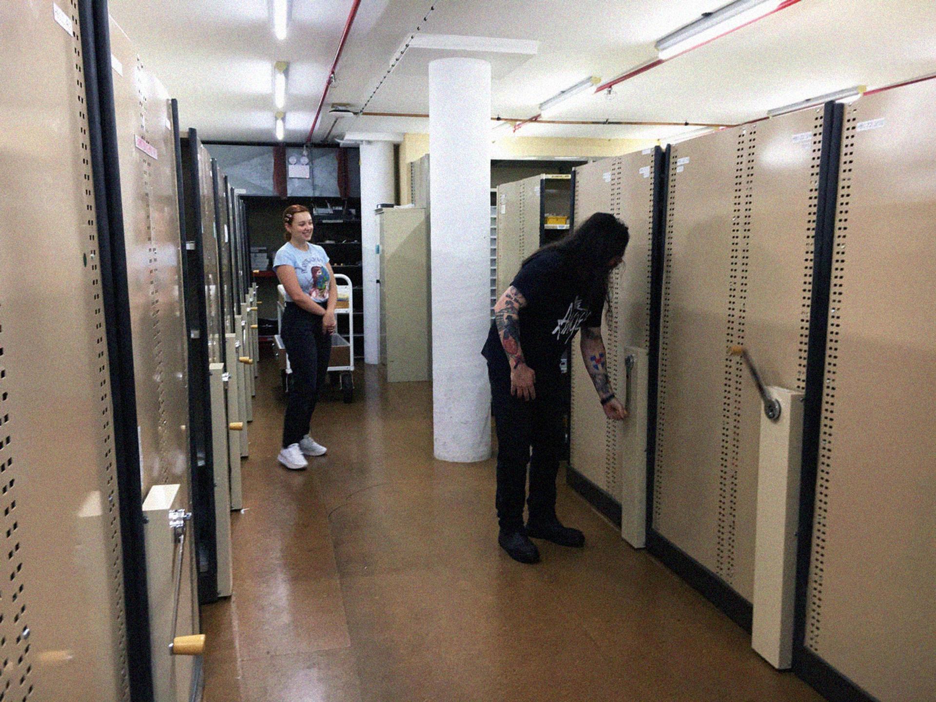 Two figures in basement housing collection.