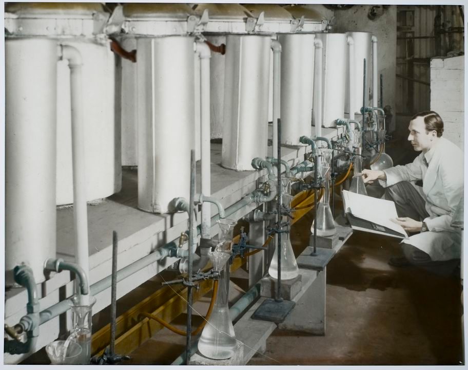 A collection of eight photographic transparencies. The content of these transparencies is the different stages of the eucalyptus oil distillation process. They are copies that are likely to have been used for a publication or were intended for a publication. The originals were probably tinted by hand.