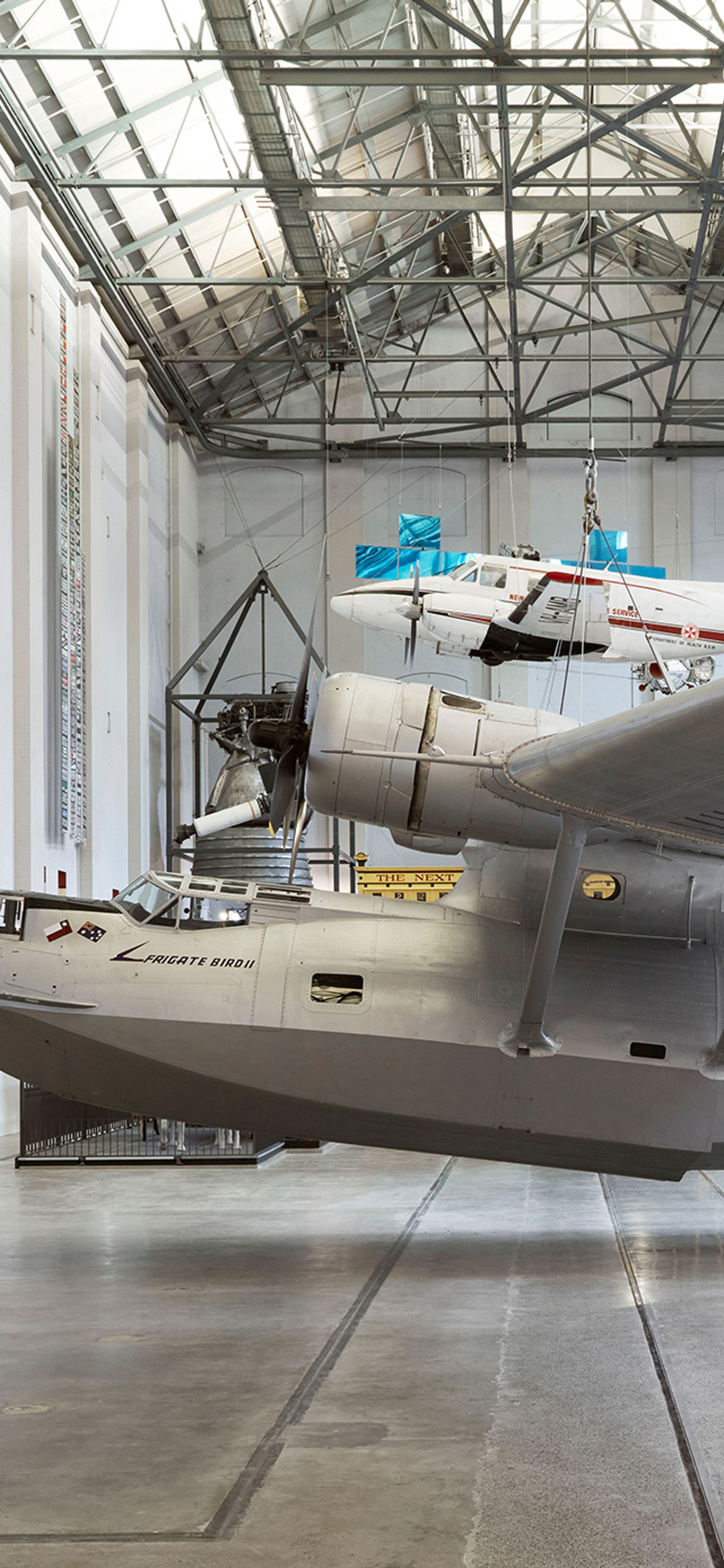 Silver plane exhibited in a large gallery space.