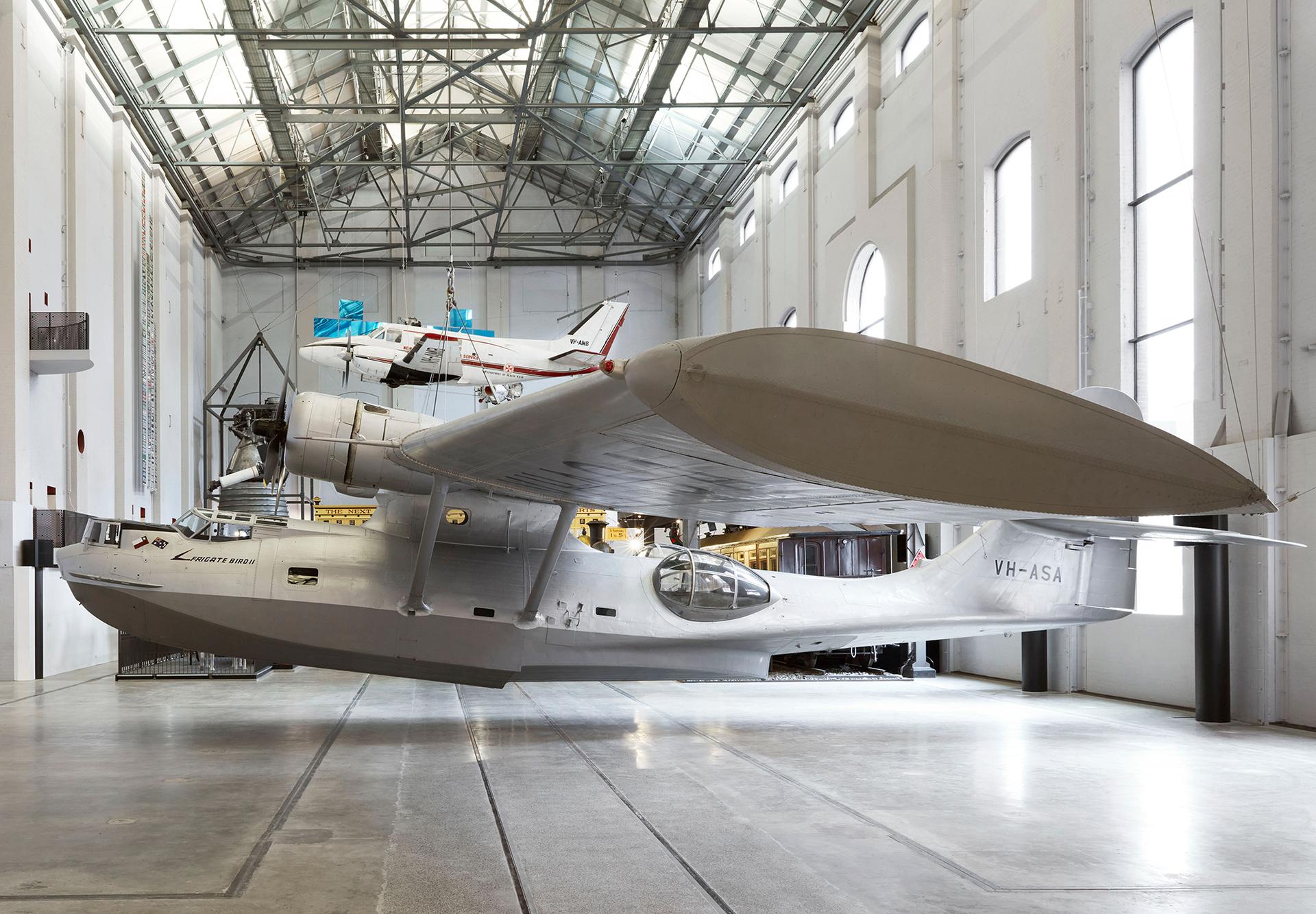 Silver plane exhibited in a large gallery space.