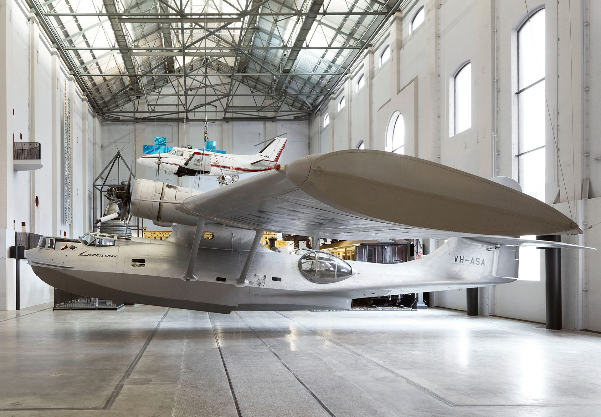 Silver plane exhibited in a large gallery space.