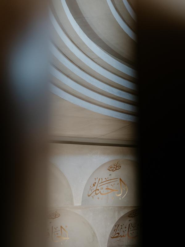 Peeping through a crack of a doorway to see the Mosque