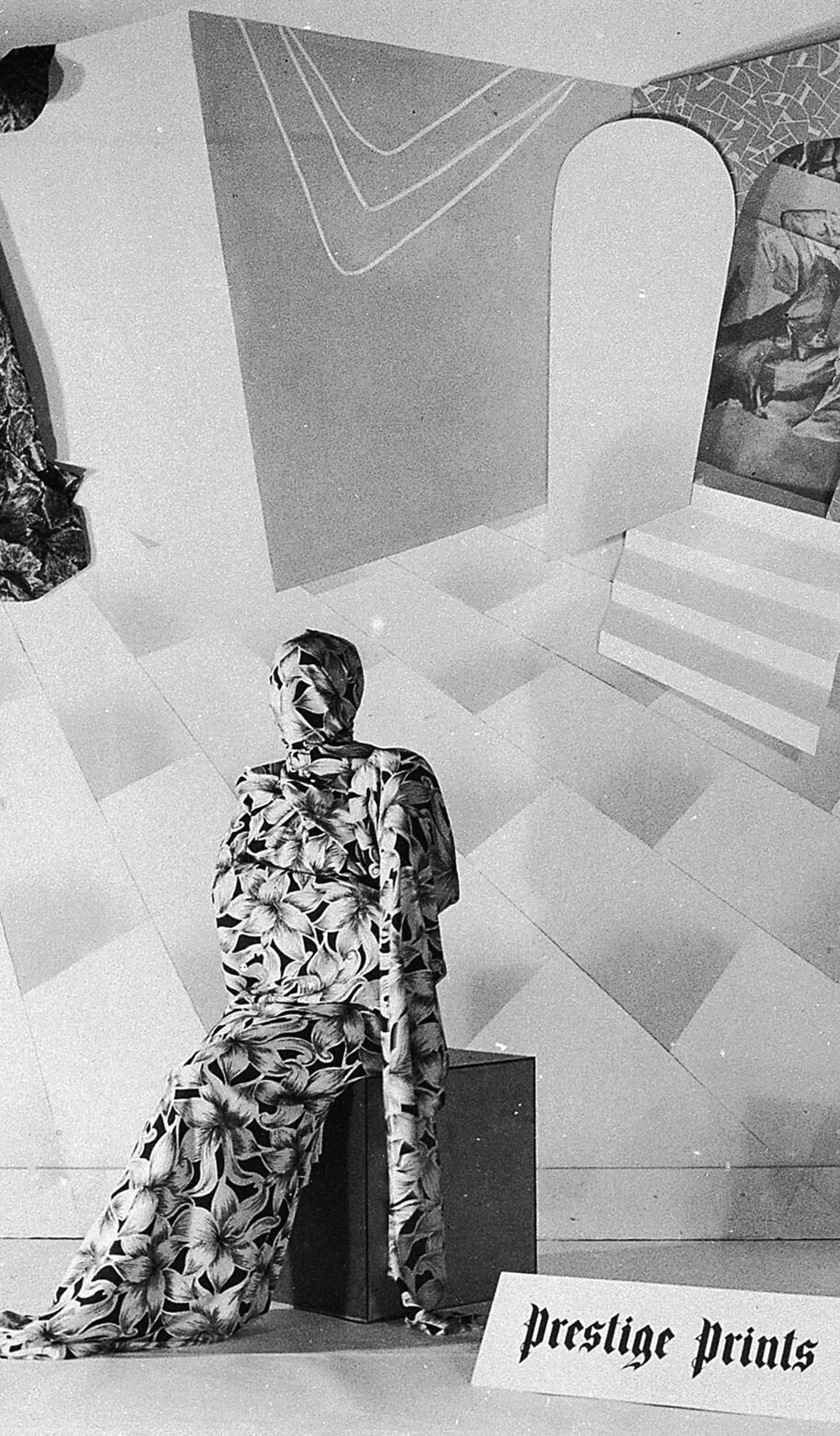Black and white photograph of theatrical fund raising event, dancer sits on a box on stage, swathed from head to toe in a screenprinted floral Prestige fabric, the collage backdrop shows surrealistic set made of prints and paper, art director Gerard Herbst, Melbourne, Victoria, Australia, 1950–1955