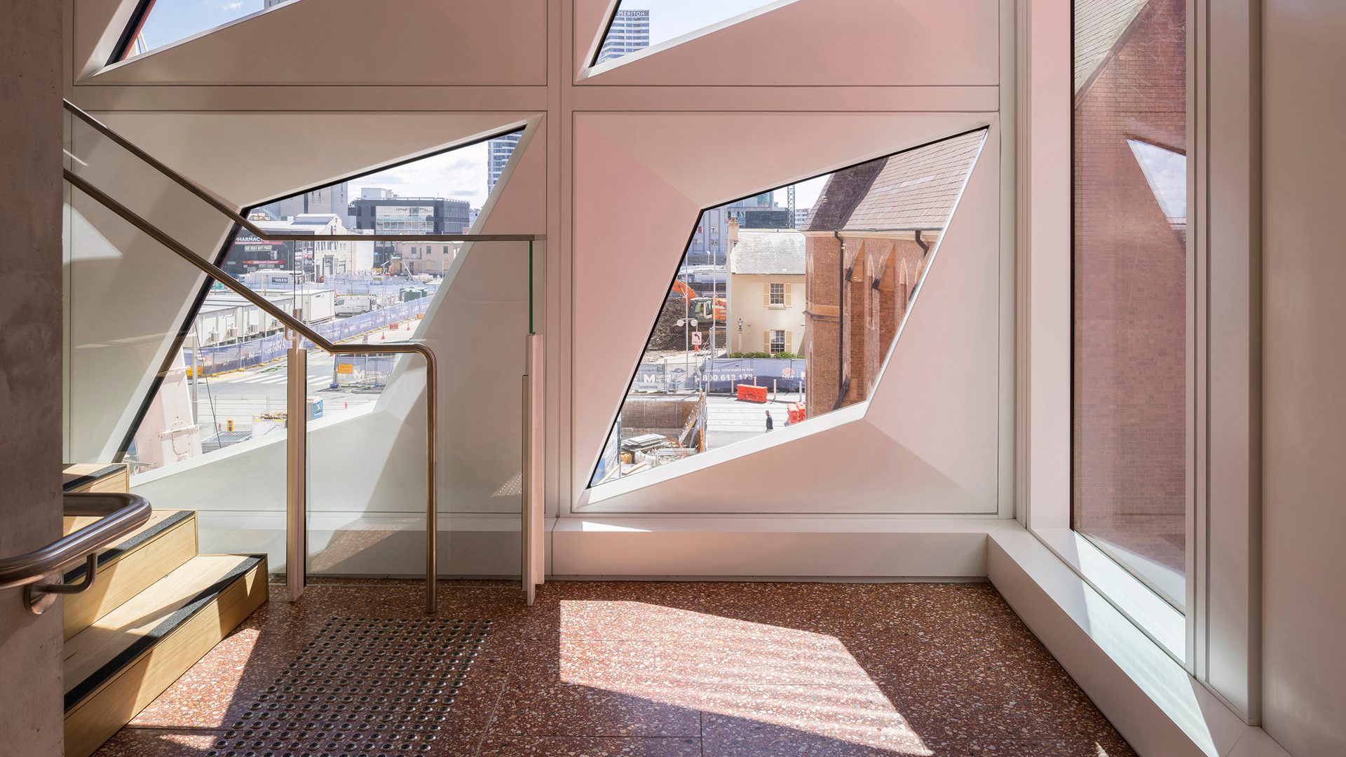 Four diamond-shaped windows in a white wall of PHIVE allow light into a staircase