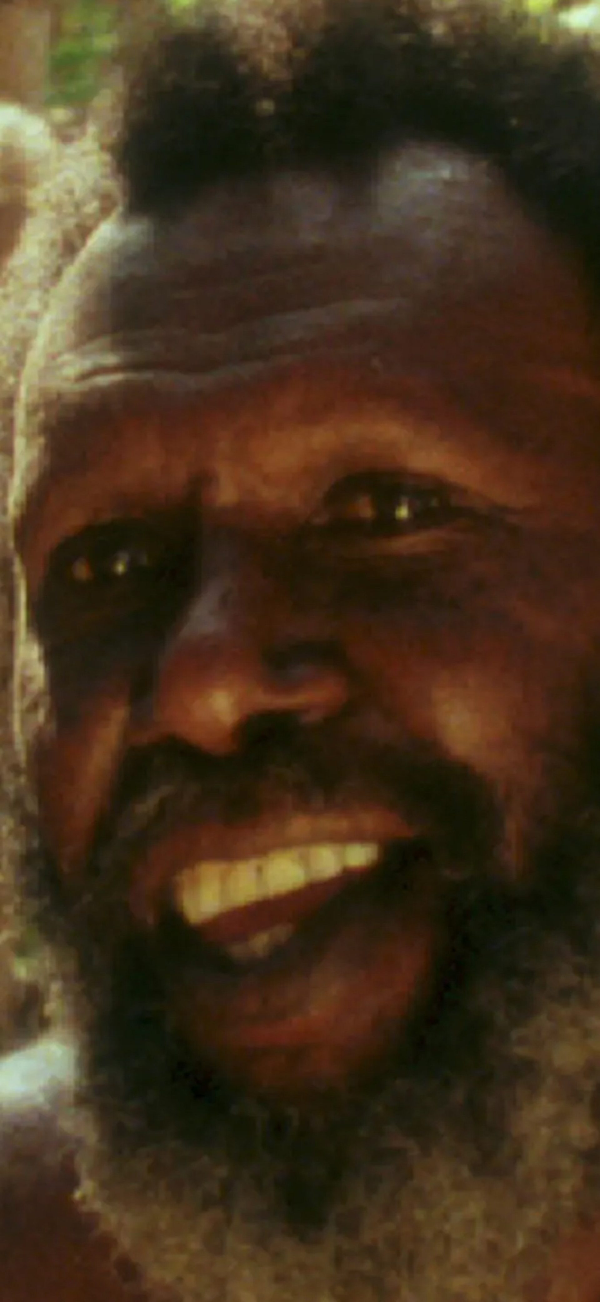 Koiki Mabo sitting within bamboo and sand backgorund.