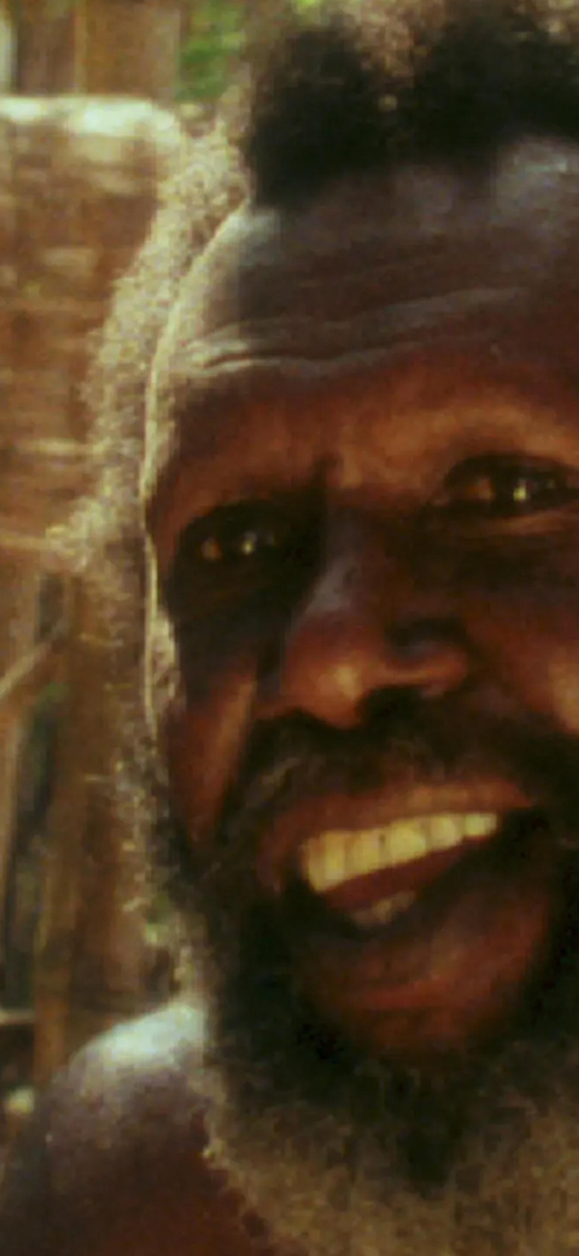 Koiki Mabo sitting within bamboo and sand backgorund.
