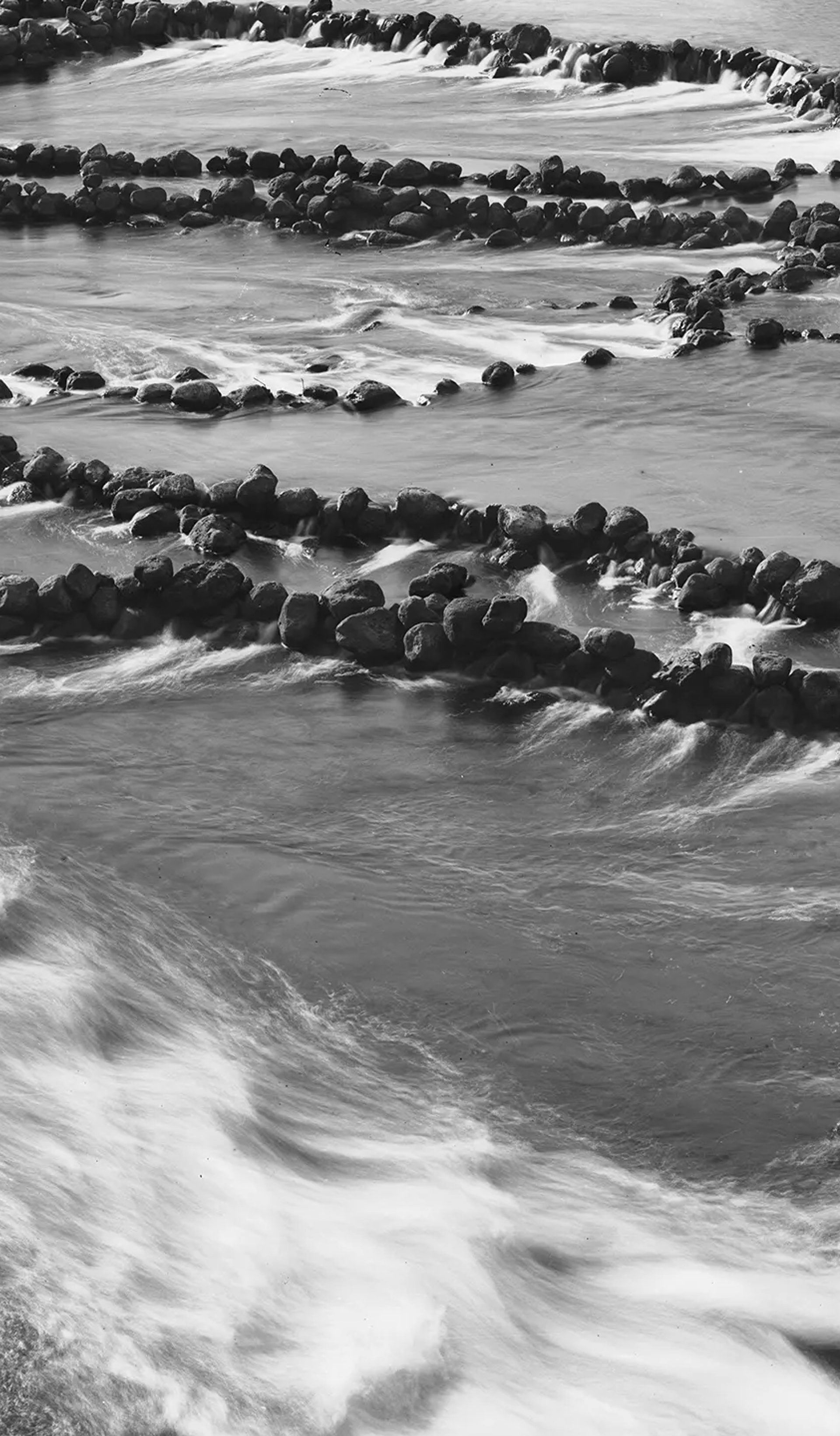 A silver gelatin dry plate glass negative in landscape format. A silver gelatin dry plate glass negative in landscape format. The image shows fish traps in a section of the Darling River. The fish traps consist of low stone walls constructed on the river bed. The walls are arranged to form cul de sacs that trap the fish. The Tyrrell Collection Inventory records the above caption but does not attribute the negative to a studio.