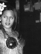 A figure looks off to the side with a grimace. They have two flowers in their hair.